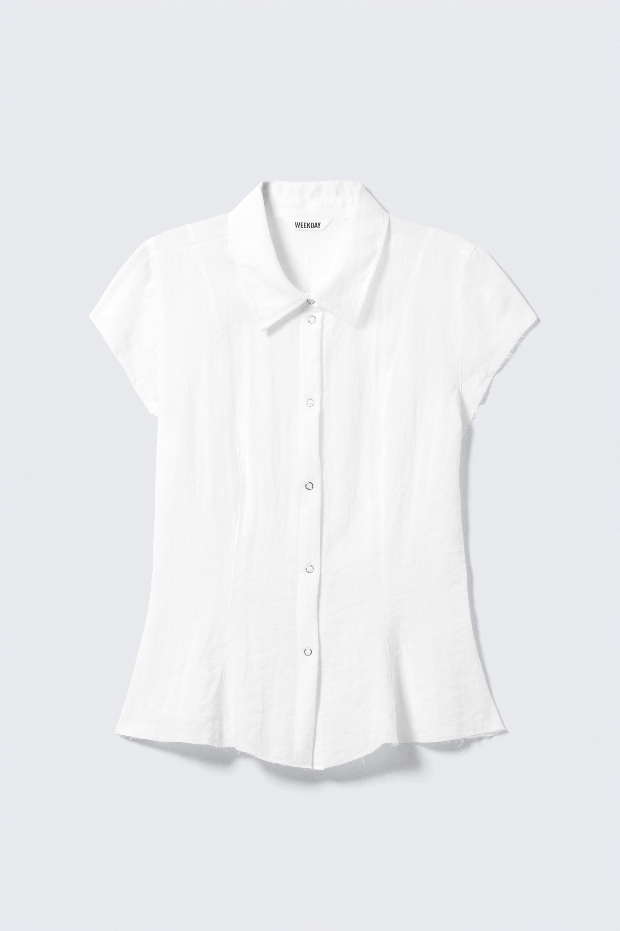 Agrandir l'image: Une chemise blanche à manches courtes présente une vue de face, avec un col pointu orné d'une étiquette 'WEEKDAY' bien visible et une patte de boutonnage complète avec des pressions. La chemise affiche une silhouette ajustée, définie par des coutures verticales, avec des manches courtes à bords bruts et un ourlet effiloché.