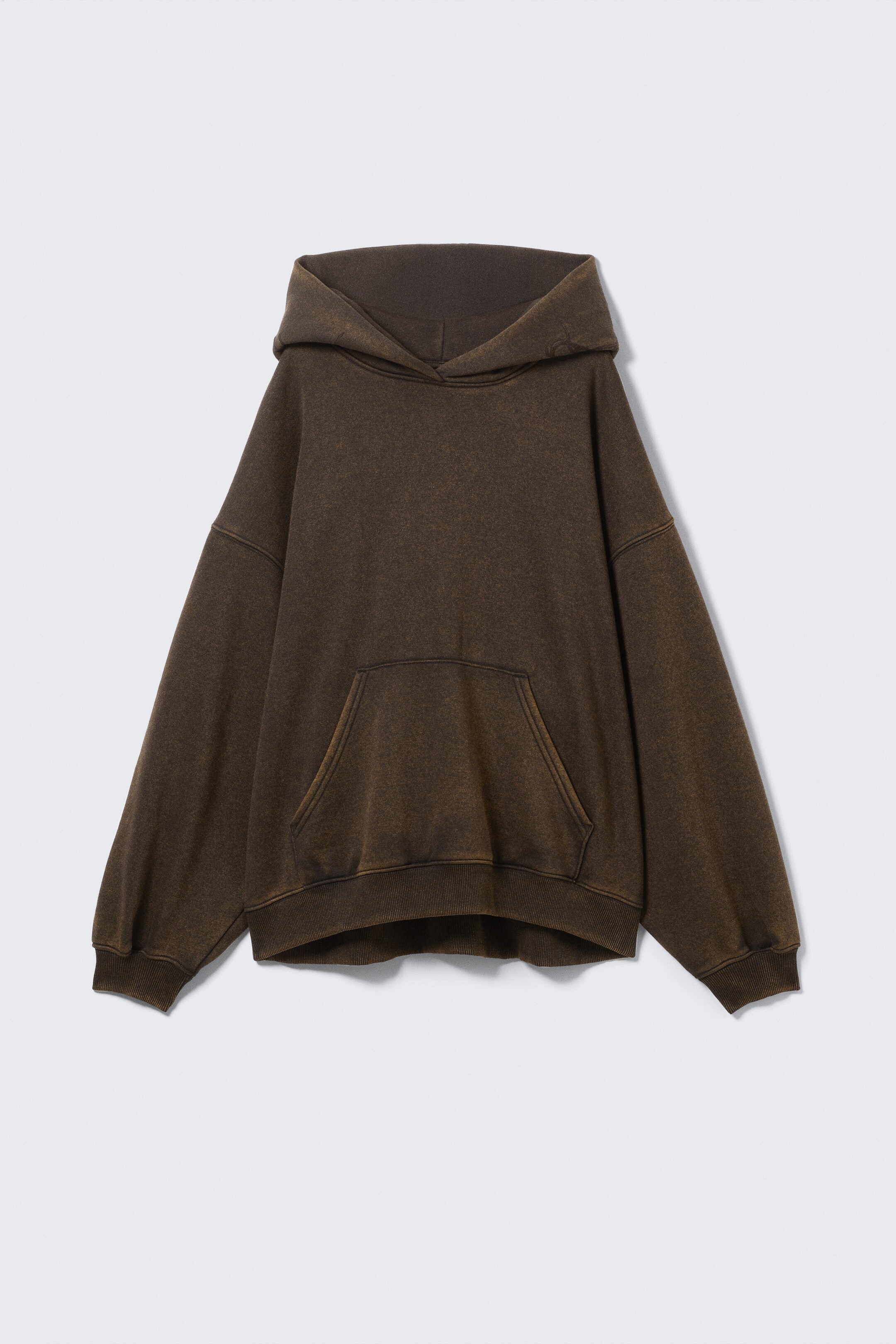 View larger image: An oversized, dark brown hoodie is being presented from the front. It is featuring a washed fabric texture, dropped shoulders, a large kangaroo pocket, and ribbed cuffs and hem.