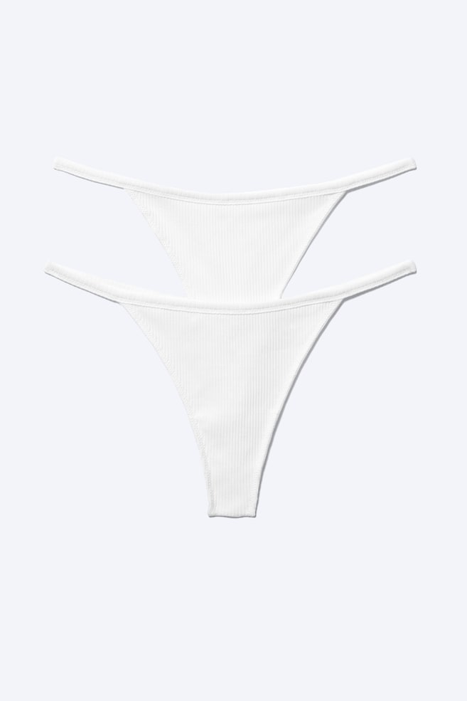 Ein Zweierpack weiße Mid-Rise-Tanga-Strings wird von vorne gezeigt, mit einer gerippten Baumwollstruktur und einem elastischen Bund. - 1