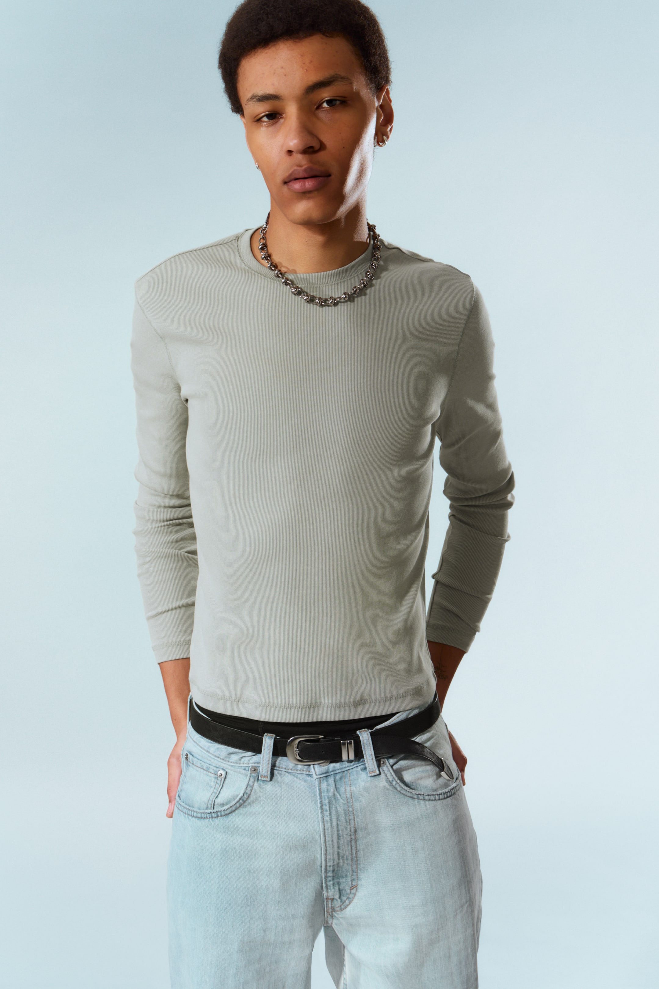 Größeres Bild ansehen: Ein hellgrünes, geripptes Langarmshirt wird von vorne präsentiert und sitzt schmal. Es verfügt über einen gerippten Rundhalsausschnitt und lange Ärmel mit gerippten Bündchen; der Saum ist in die Hose gesteckt.