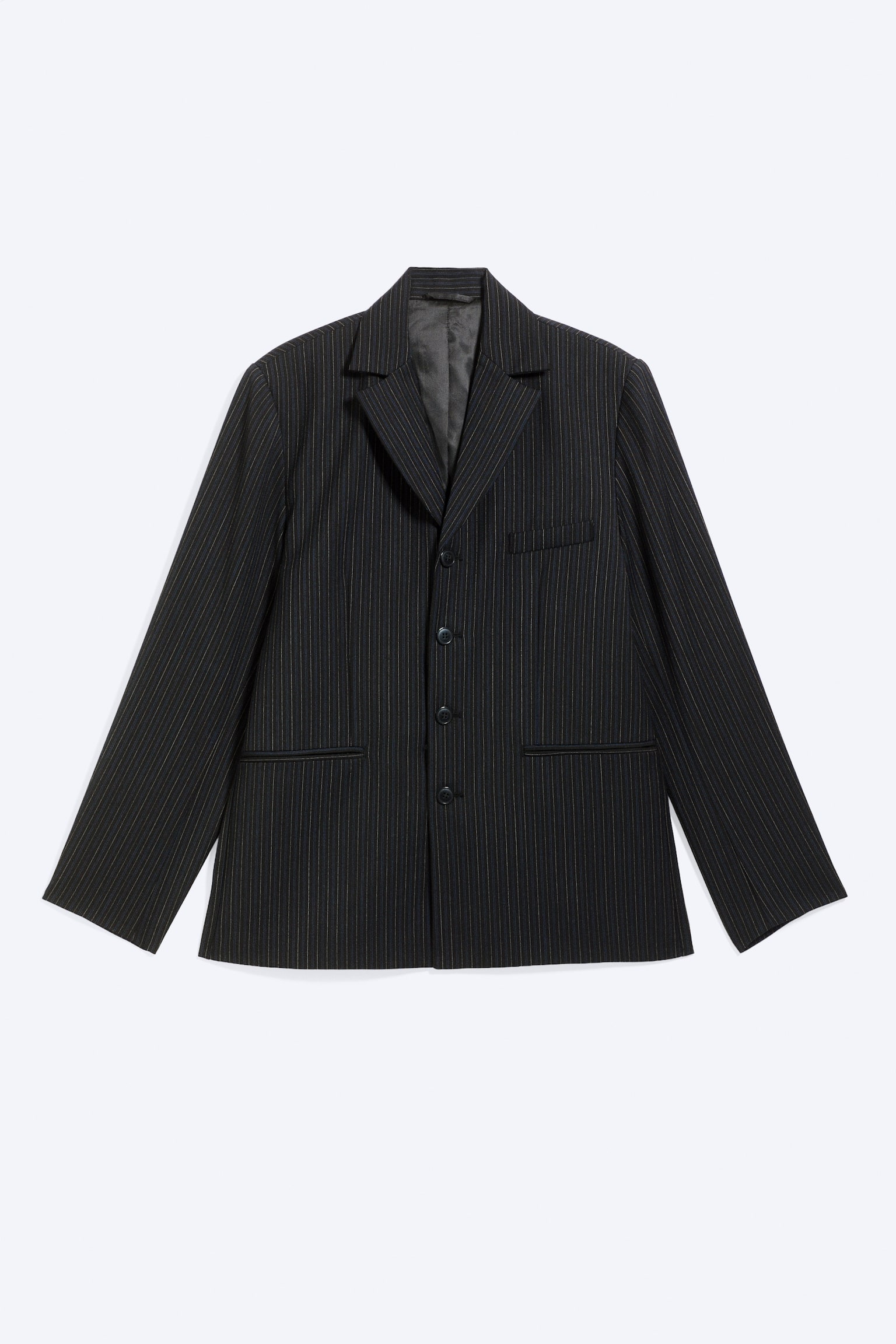 Un blazer scuro a righe sottili, visto frontalmente, mette in risalto una silhouette strutturata dalla vestibilità regular, con revers classici e chiusura monopetto a quattro bottoni. La giacca presenta una tasca a filetto sul petto, due tasche a filetto inferiori sul davanti e una fodera interna grigia a vista.