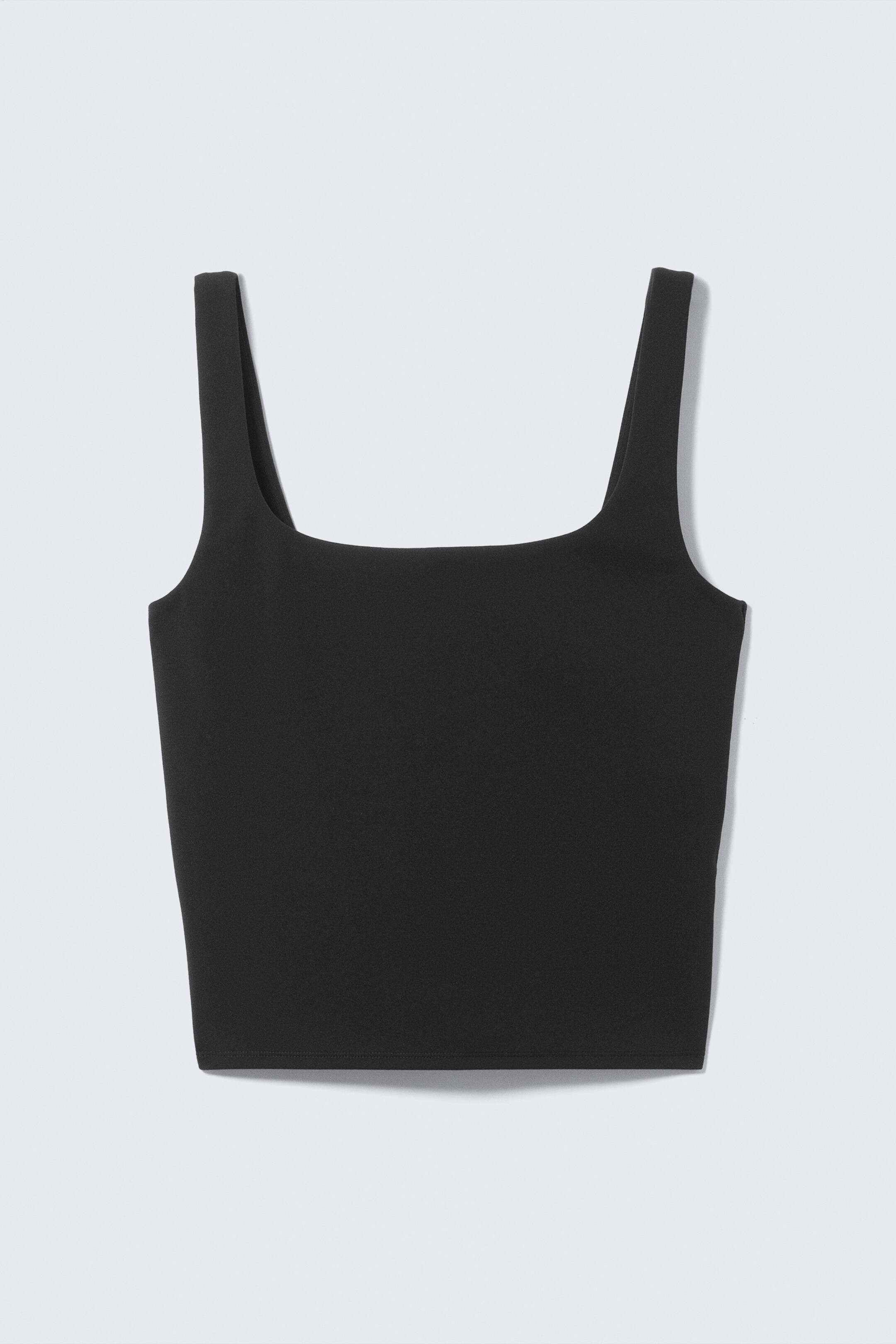 Grotere afbeelding bekijken: Een zwarte tanktop wordt van voren getoond, met een vierkante halslijn, brede schouderbanden, een gladde matte afwerking en een aansluitende, korte lengte.