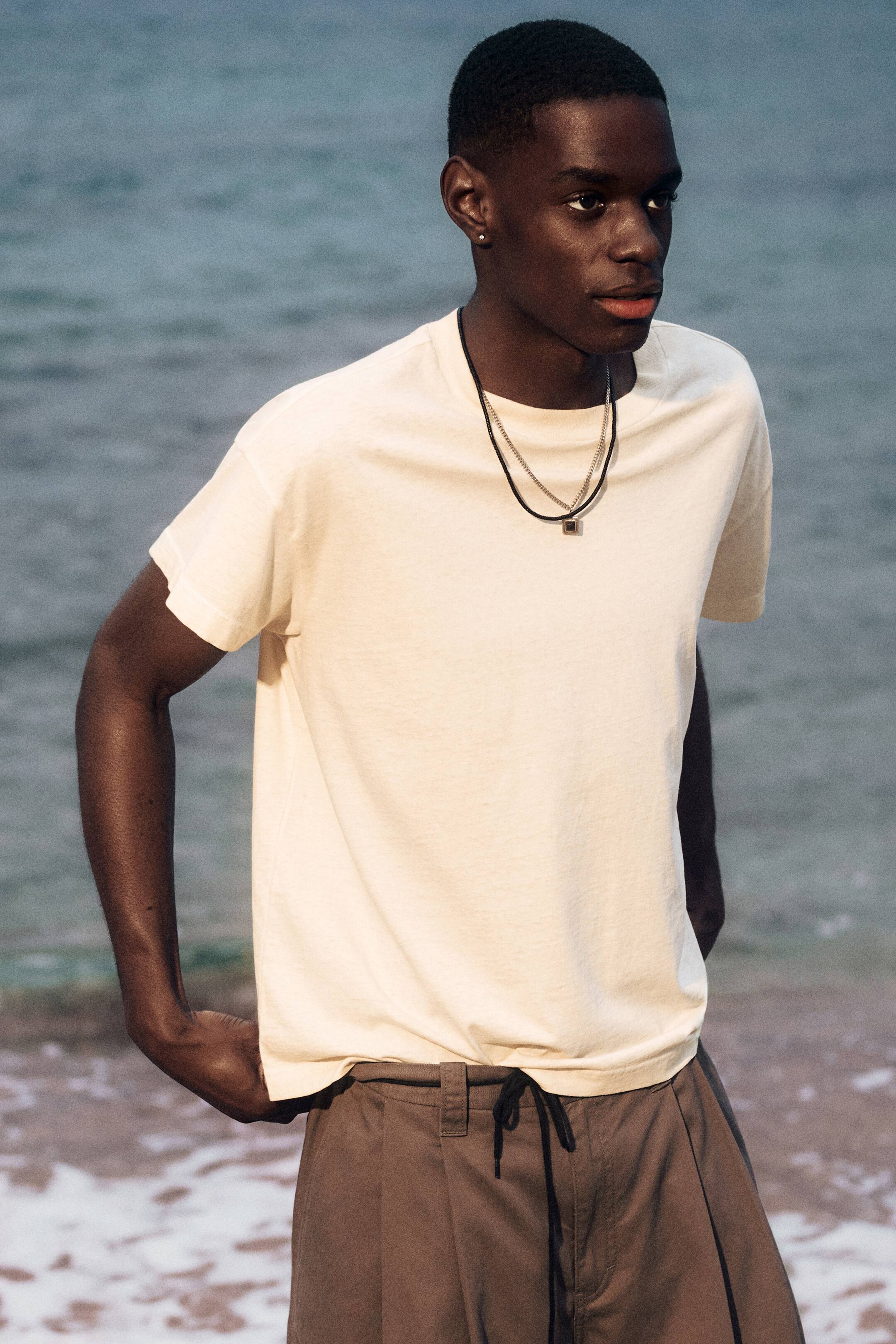 View larger image: A boxy T-shirt, crafted from soft cotton jersey, features a relaxed silhouette with slightly dropped shoulders and short cap sleeves. It also showcases a vintage wash and distressed details at its ribbed neckline and hem, creating a worn-in look.