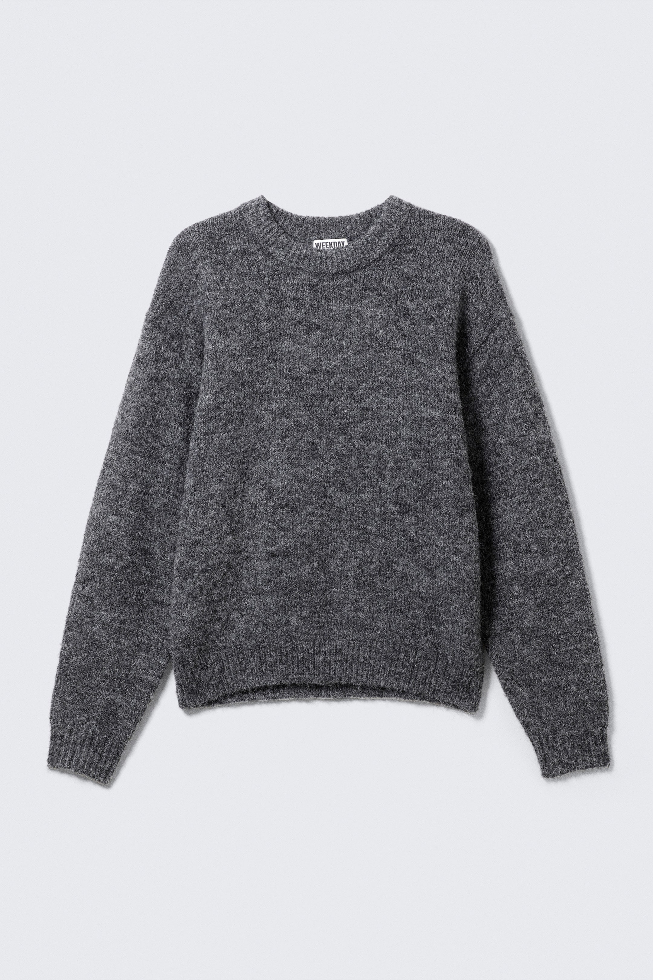 Grösseres Bild ansehen: Ein dunkelgrauer, flauschiger Strickpullover zeigt seine VORDERSEITE, mit regulärer Passform, einem runden gerippten Ausschnitt sowie gerippten Bündchen und Saum.