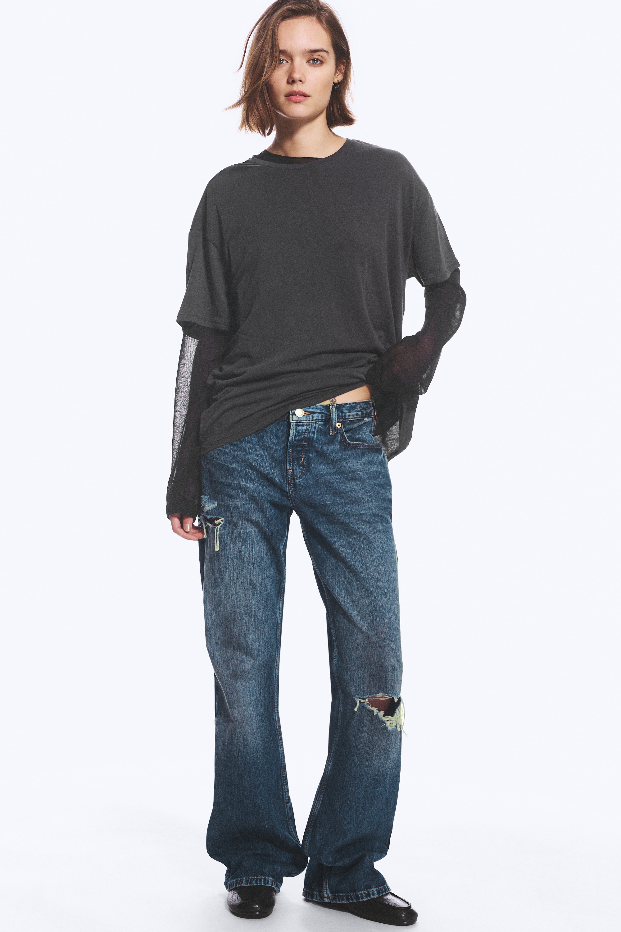ÐÑнки bootcut Ñ Ð½Ð¸Ñка ÑÐ°Ð»Ð¸Ñ Ð¸ Ñвободна кÑойка вÑв избелен Ñин деним, показани оÑпÑед, Ñ ÐºÐ»Ð°ÑиÑеÑки дизайн Ñ Ð¿ÐµÑ Ð´Ð¶Ð¾Ð±Ð°, еÑÐµÐºÑ Ð½Ð° изÑÑÑкване и ÑкÑÑани деÑайли на дÑÑноÑо гоÑно бедÑо и лÑвоÑо колÑно.