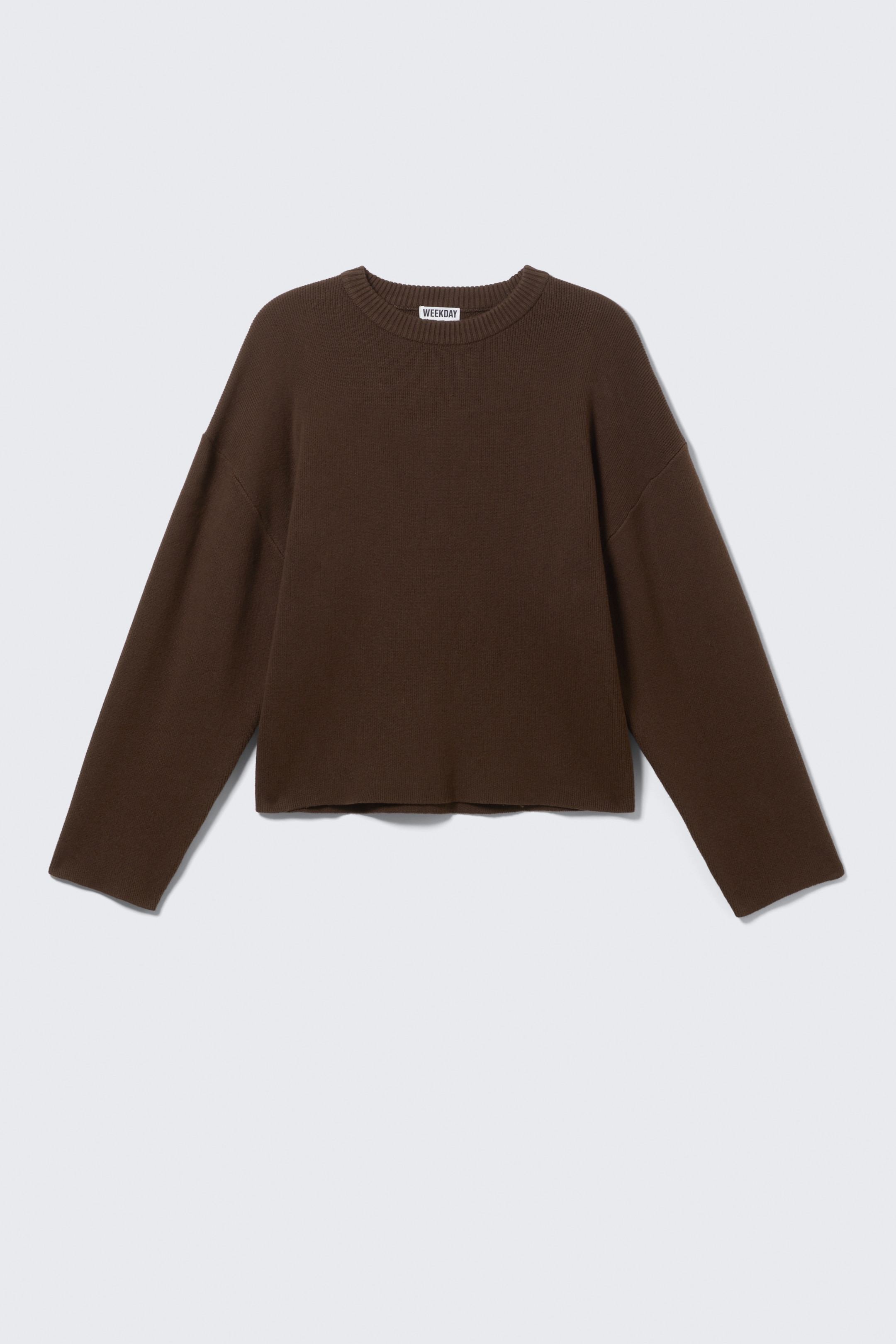 Größeres Bild anzeigen: Ein dunkelbrauner, entspannter, kastig geschnittener Pullover wird von vorne präsentiert, mit einem klassischen Rundhalsausschnitt, überschnittenen Schultern und weiten Ärmeln. Seine sauberen, nicht gerippten Säume erzeugen einen glatten, nahtlosen Look.