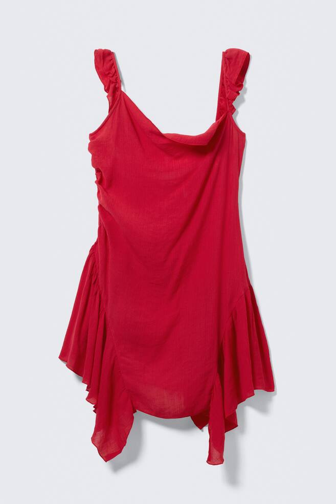 Un vestido mini rojo se presenta de frente. Presenta tirantes con volantes, un escote drapeado, fruncidos en su lado izquierdo y un dobladillo asimétrico con volantes fluidos. - 1