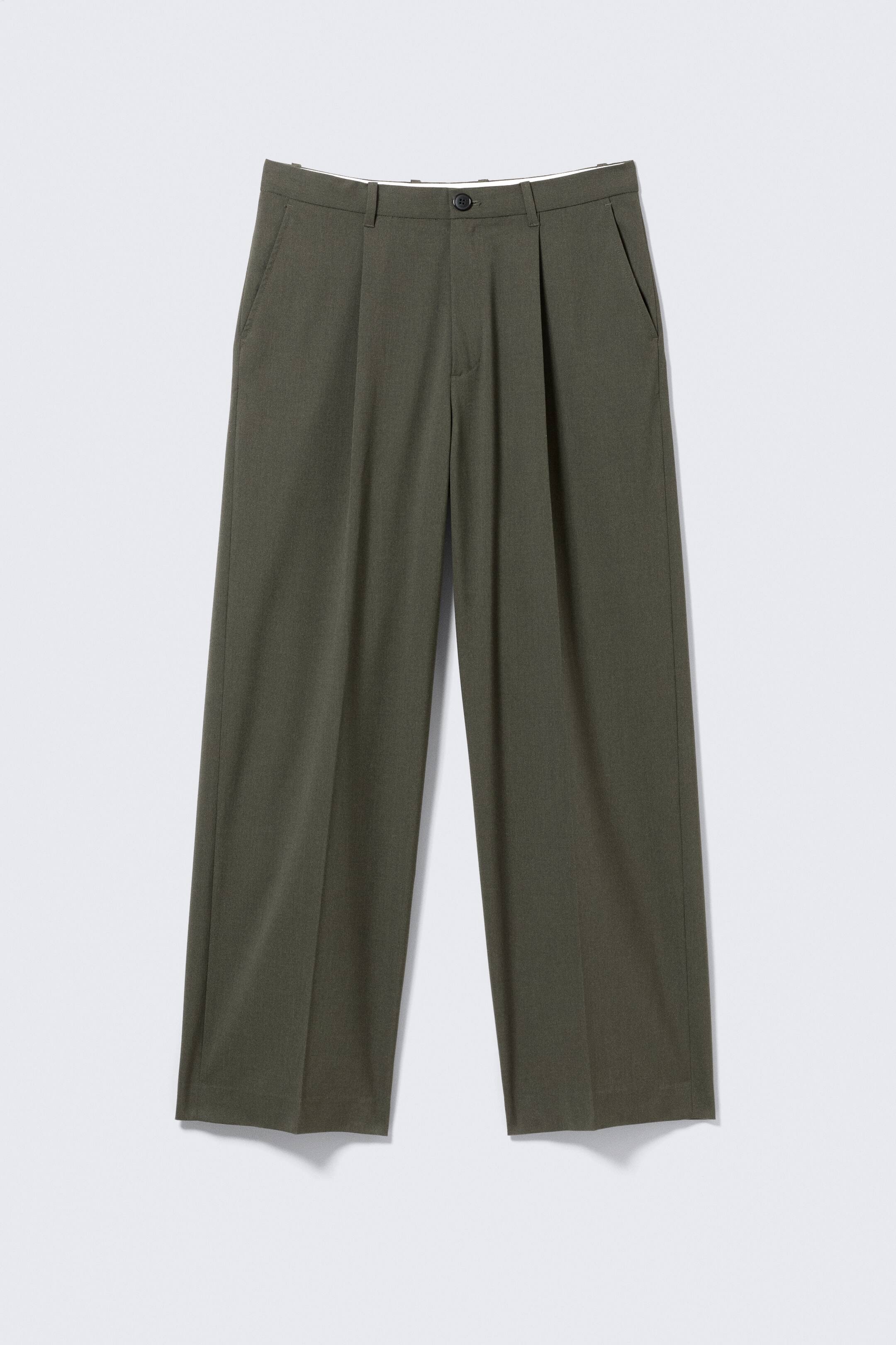 Agrandir l'image: Un pantalon surdimensionné de couleur vert olive est présenté de face, avec une taille plate dotée d'une fermeture à bouton et à glissière. Il est équipé de deux poches latérales inclinées, de plis marqués à l'avant et de plis pressés courant le long du centre de chaque jambe large.