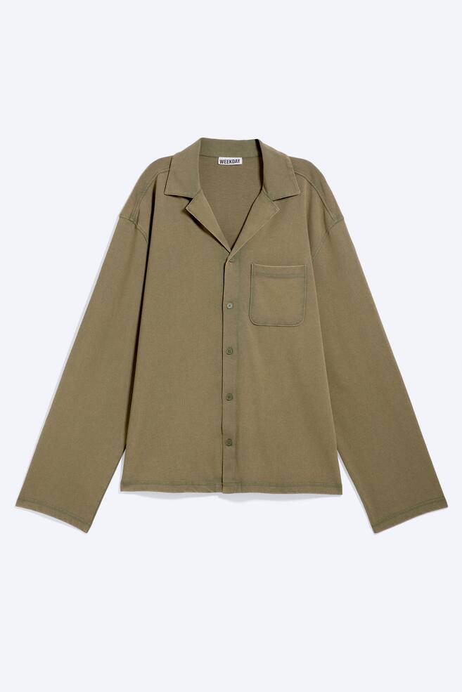Une chemise en maille vert olive à manches longues présente son devant, avec un col à revers, une patte de boutonnage complète avec des boutons assortis, et une poche plaquée sur la poitrine gauche. - 1