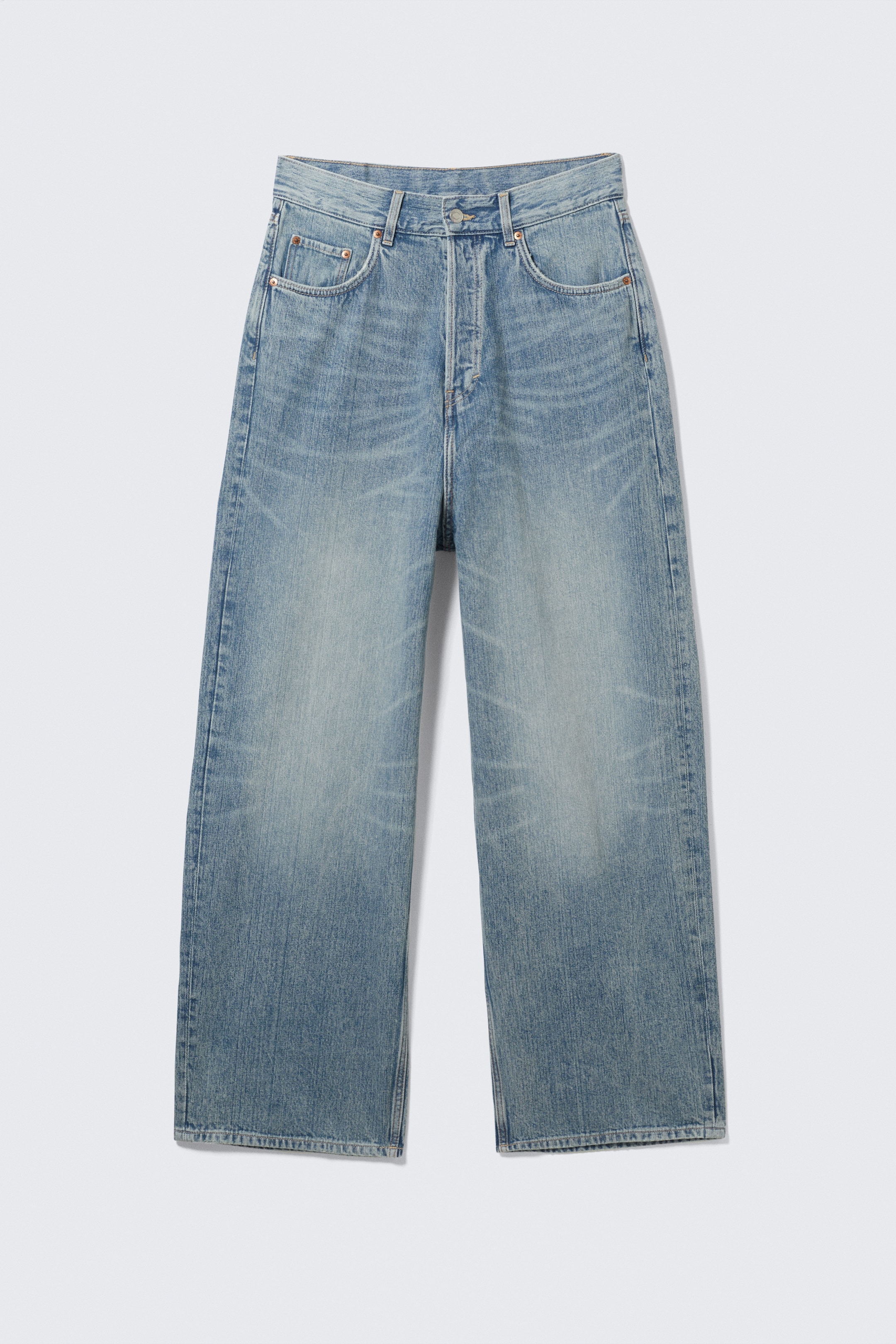 View larger image: A light blue, wide-leg pair of jeans is being displayed from the front, featuring a high-waisted fit, a button fly closure, and two front scoop pockets with a coin pocket. The denim is showing a faded wash with whiskering on the thighs.
