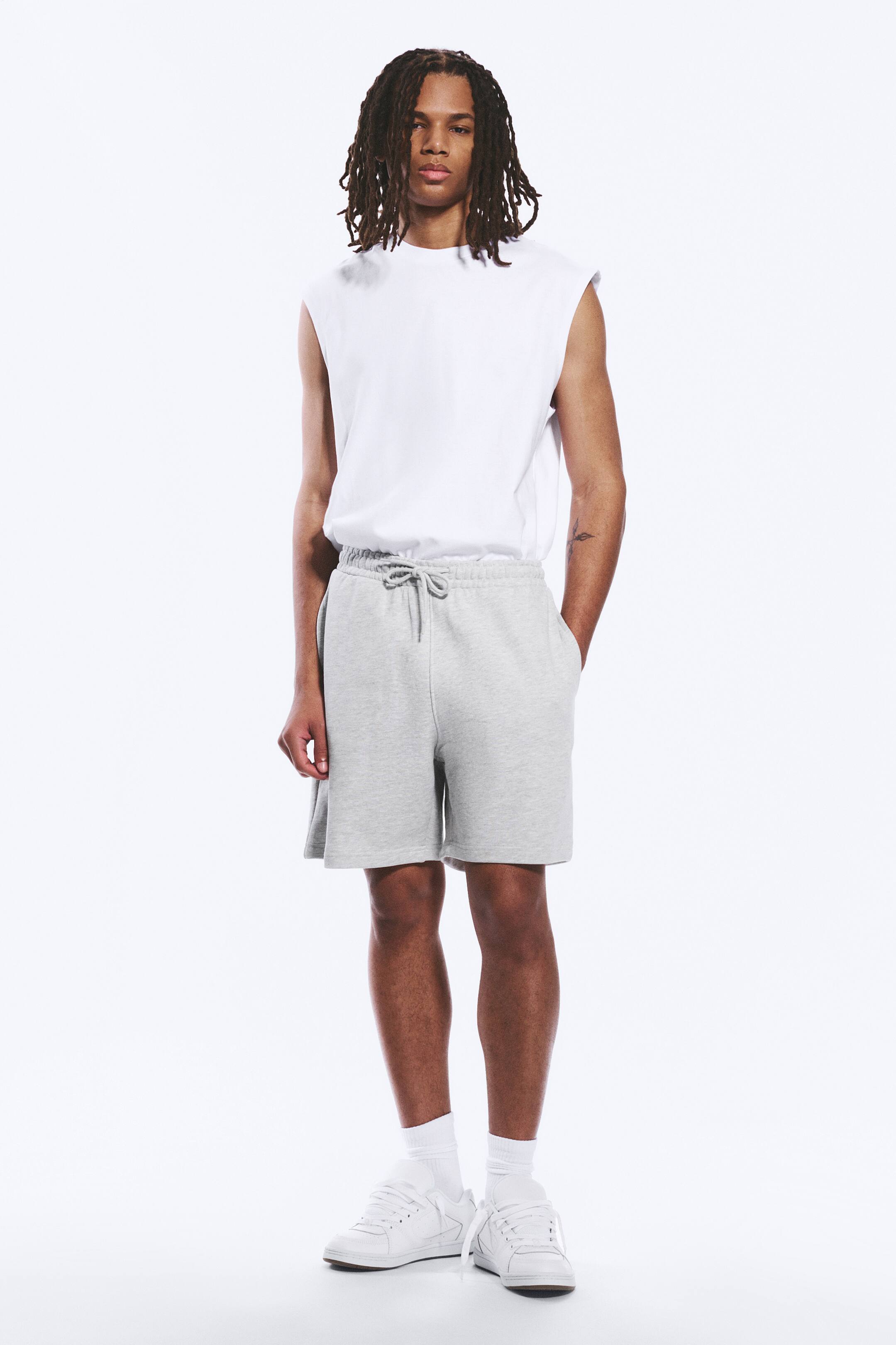 Se større billede: Heather grå sweatshorts med elastisk linning og snøre samt synlige sidelommer, der går til lige over knæet.