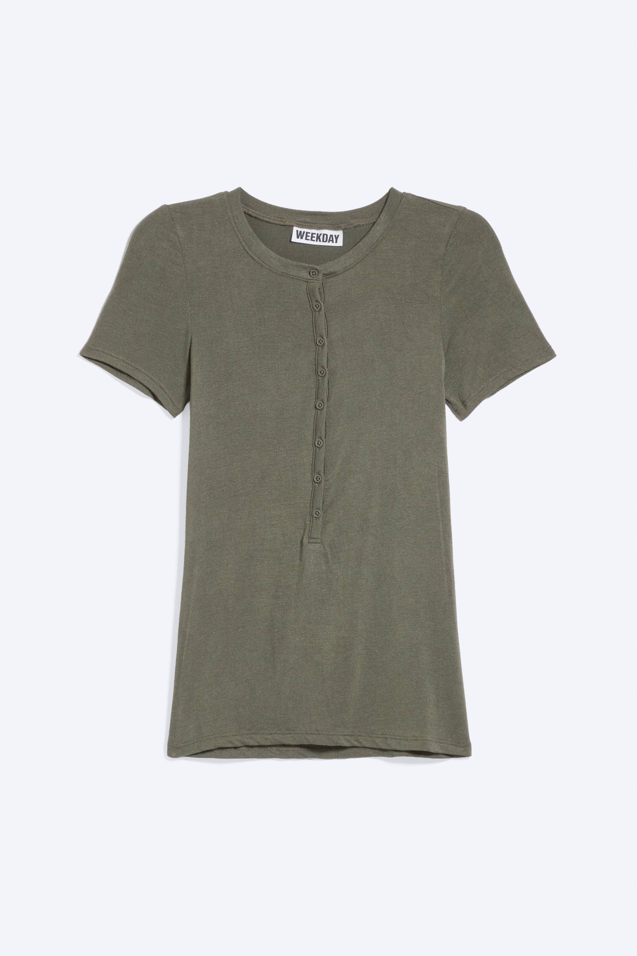 Grotere afbeelding bekijken: Een olijfgroen t-shirt met korte mouwen is van voren te zien, met een ronde halslijn en een wit "WEEKDAY" label en een Henley-sluiting met zeven knopen. Het t-shirt is gemaakt van een fijne geribde breistof.