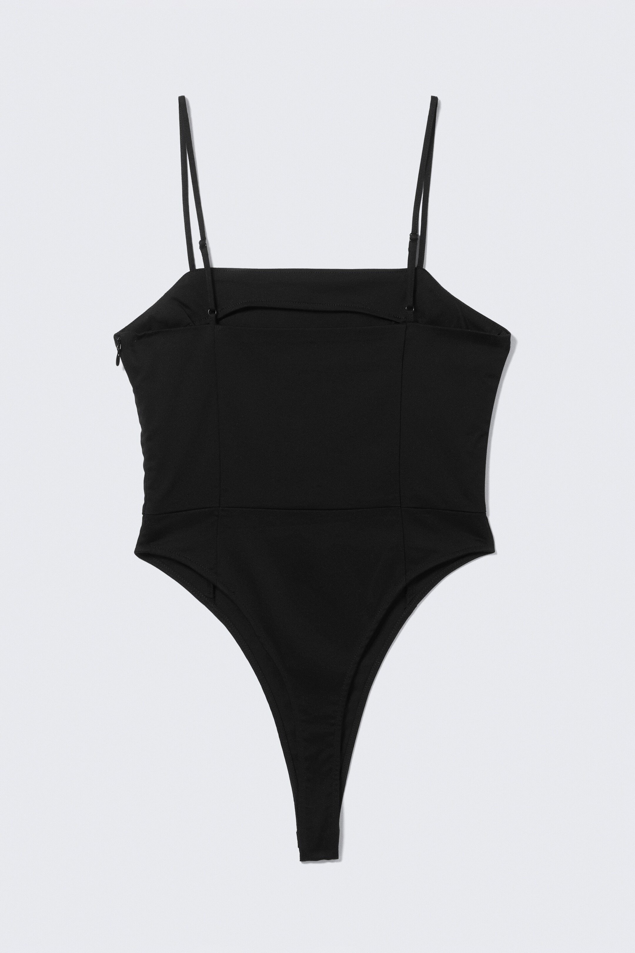 Agrandir l'image: Le body noir affiche sa vue de dos, avec un décolleté droit dans le dos et de fines bretelles réglables. Il présente un design de jambe échancrée, et une fermeture éclair invisible apparaît sur le côté gauche.