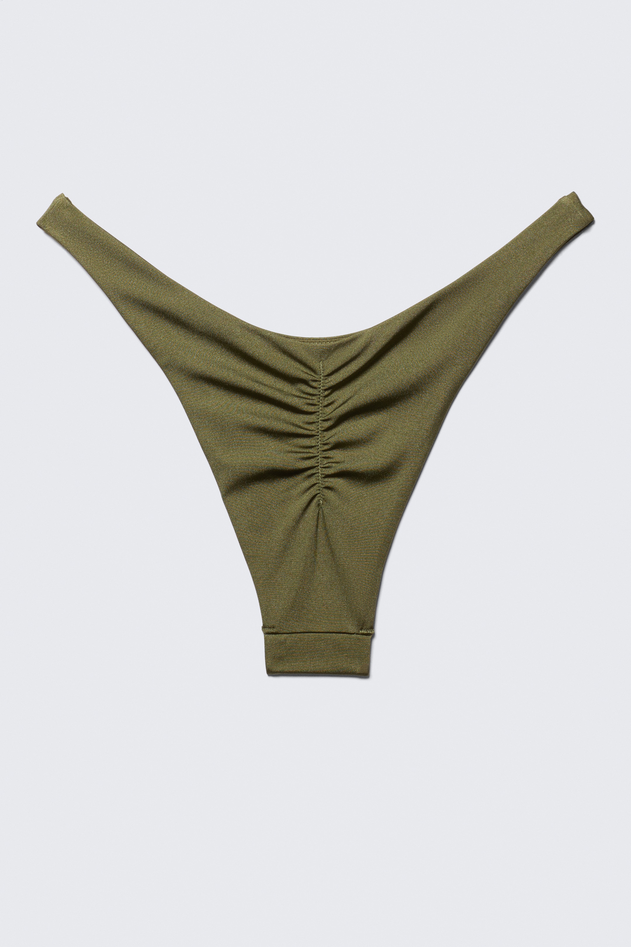 Ver imagen más grande: Un bikini de tanga verde oliva está mostrando su parte trasera, con un sutil brillo en la tela, detalles fruncidos a lo largo de la costura central y aberturas de pierna de corte alto.
