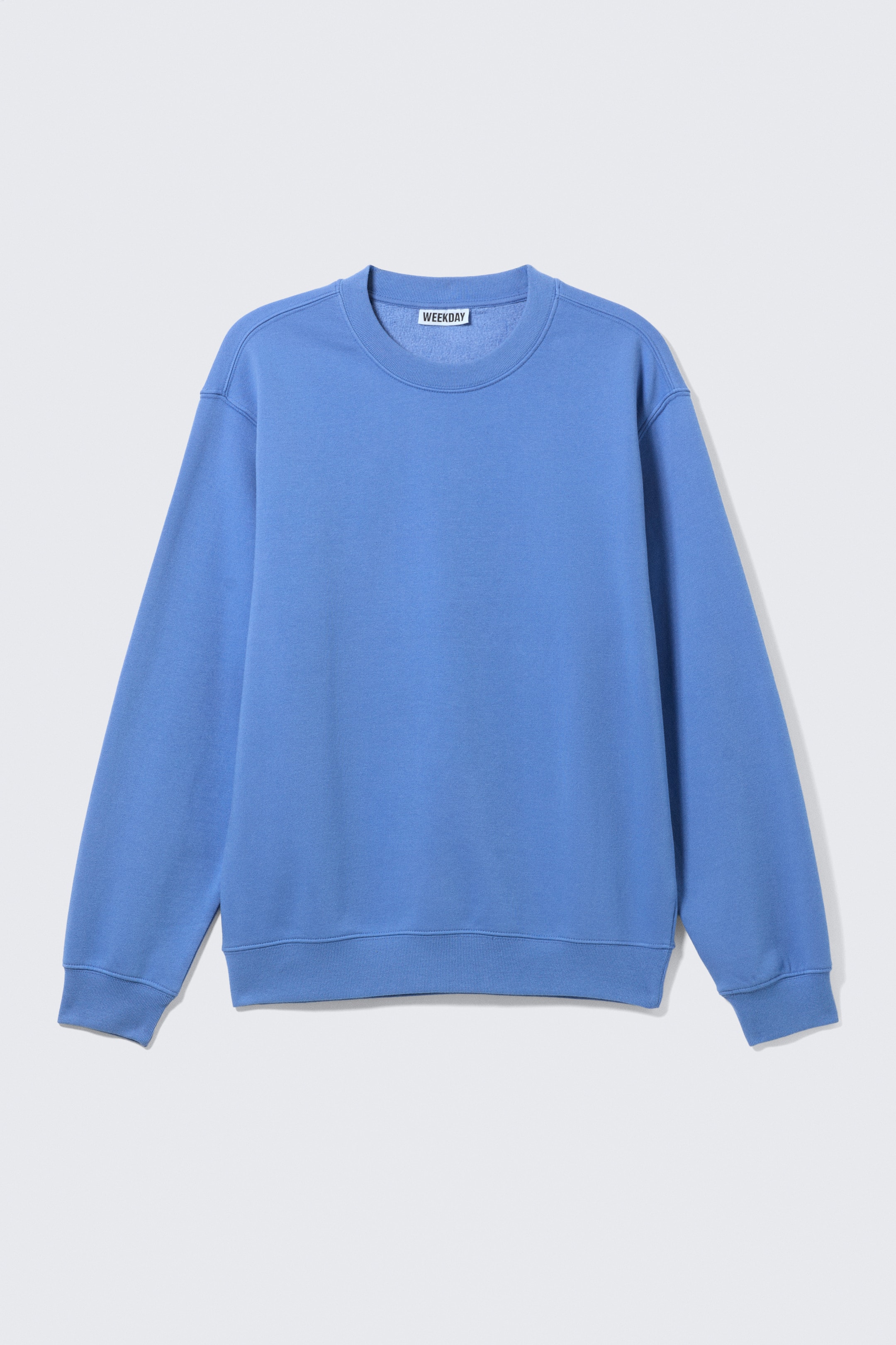 Visualizza immagine più grande: Una felpa blu con collo rotondo viene presentata dal FRONTE, caratterizzata da una vestibilità regolare con spalle leggermente scese, un collo rotondo a coste, polsini a coste e un orlo a coste.