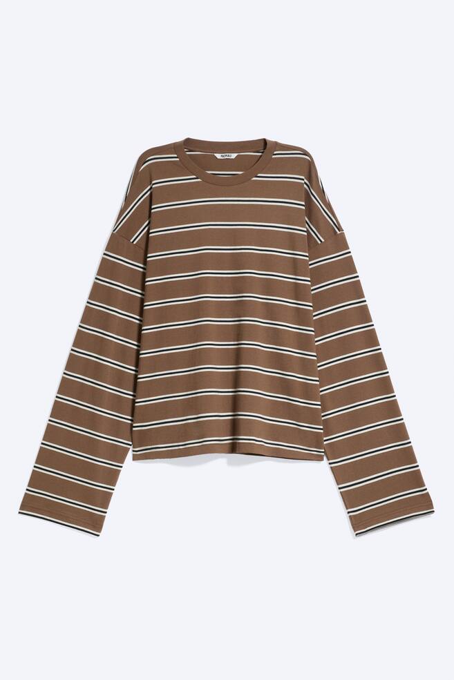 En brun langÃ¦rmet T-shirt med vandrette sorte og hvide striber ses forfra og fremhÃ¦ver en afslappet silhuet med sÃ¦nkede skuldre. Den har en ribstrikket rund hals og brede, lige Ã¦rmer. - 1