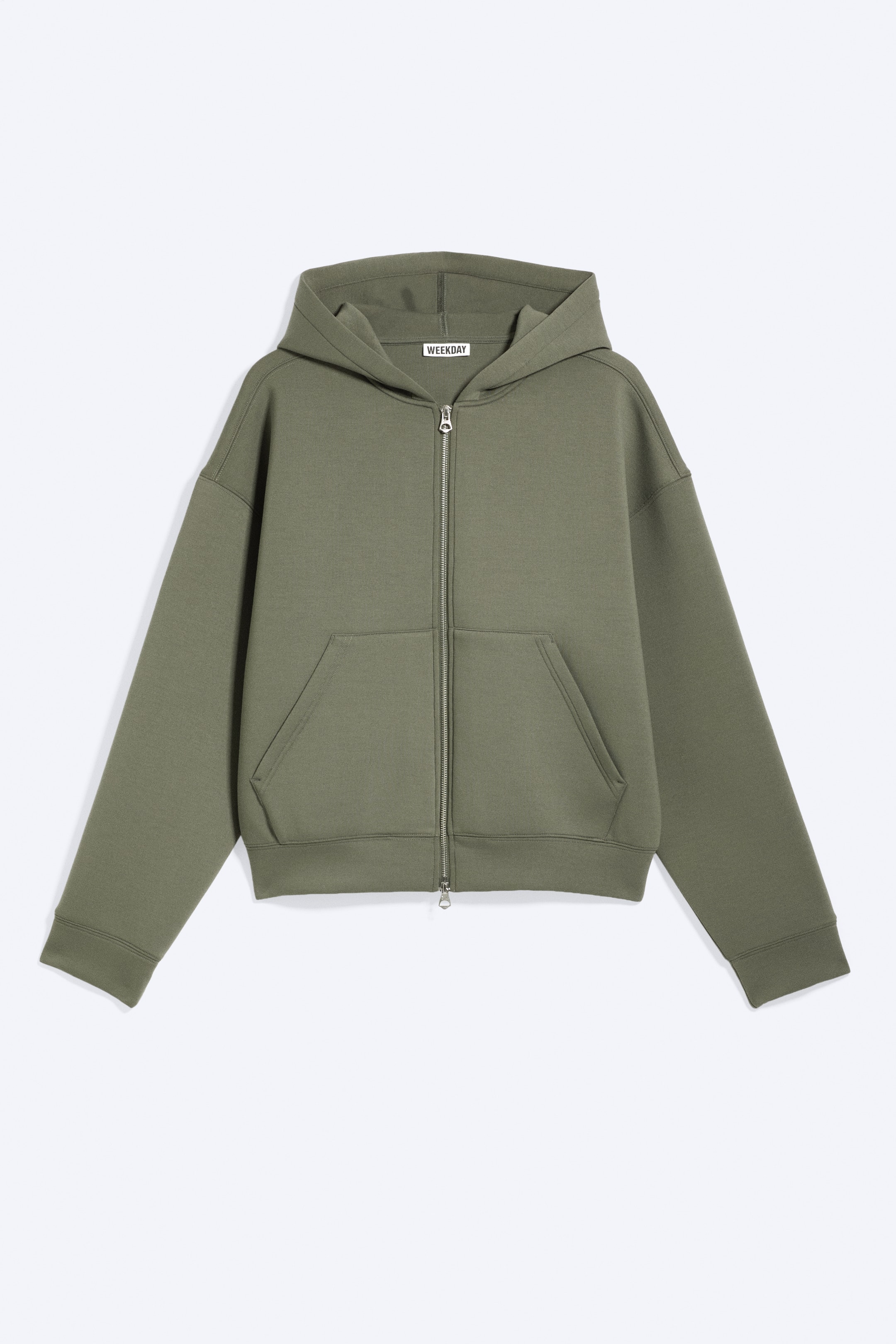 Grotere afbeelding bekijken: Een regular fit olijfgroene zip hoodie, gemaakt van een dik scuba-stof, wordt aan de voorkant getoond. Het heeft licht afhangende schouders, geribde boorden en zoom, een stevige tweerichtingsrits aan de voorkant en twee voorste kangoeroezakken.