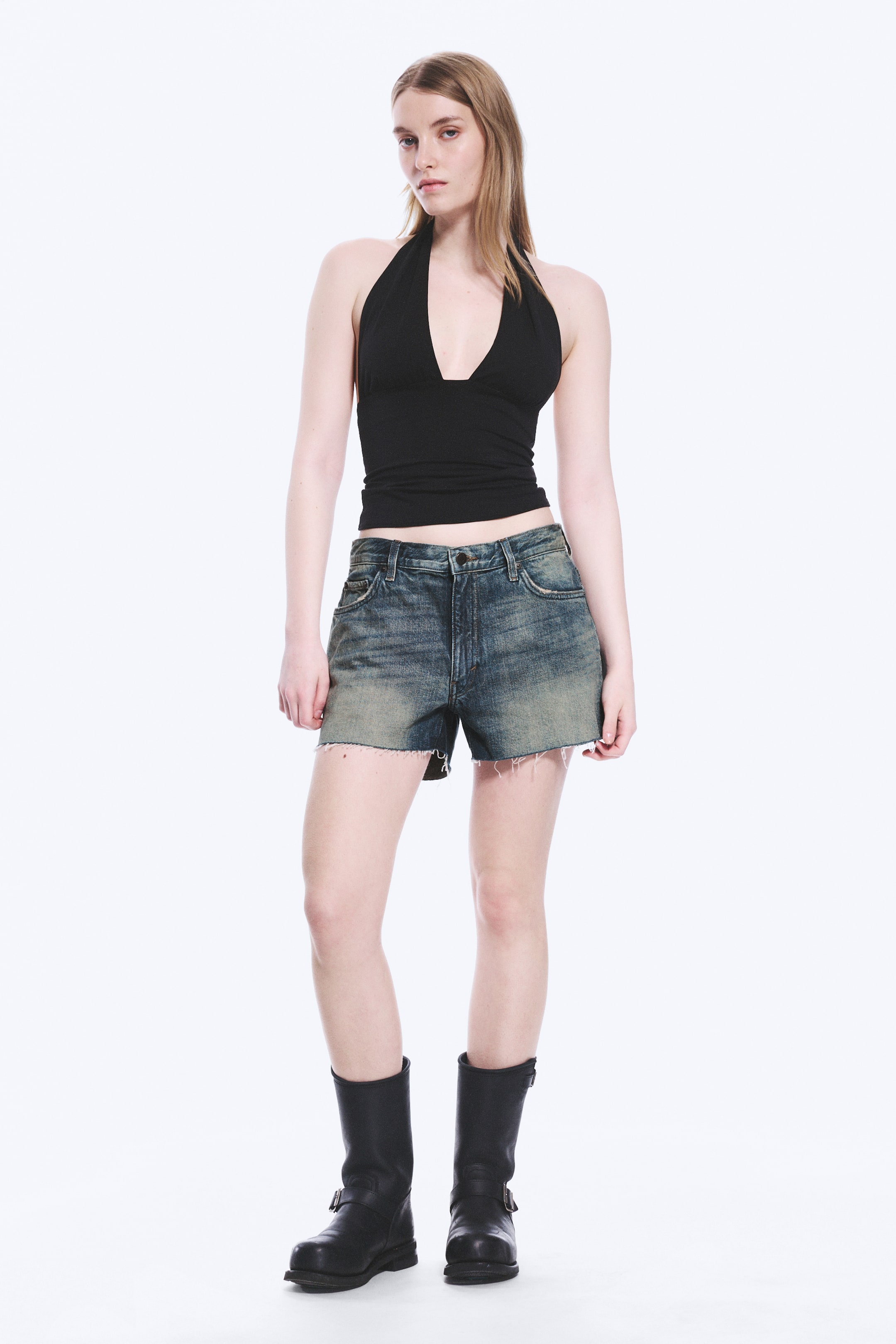 Größeres Bild ansehen: Distressed Denim-Shorts präsentieren sich in einer verwaschenen blauen Optik mit Whiskering-Details und einem ausgefransten, rohen Saum. Sie bieten eine mittelhohe Passform von vorne.