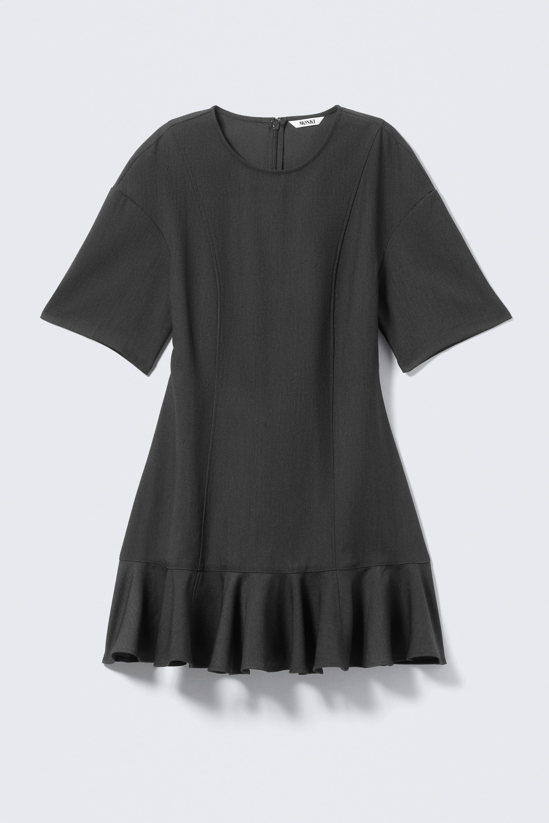 Ver imagen más grande: Un vestido gris oscuro presenta un escote redondo y mangas cortas y anchas. Costuras verticales moldean el corpiño, y un volante con volantes forma el dobladillo de la falda en línea A.