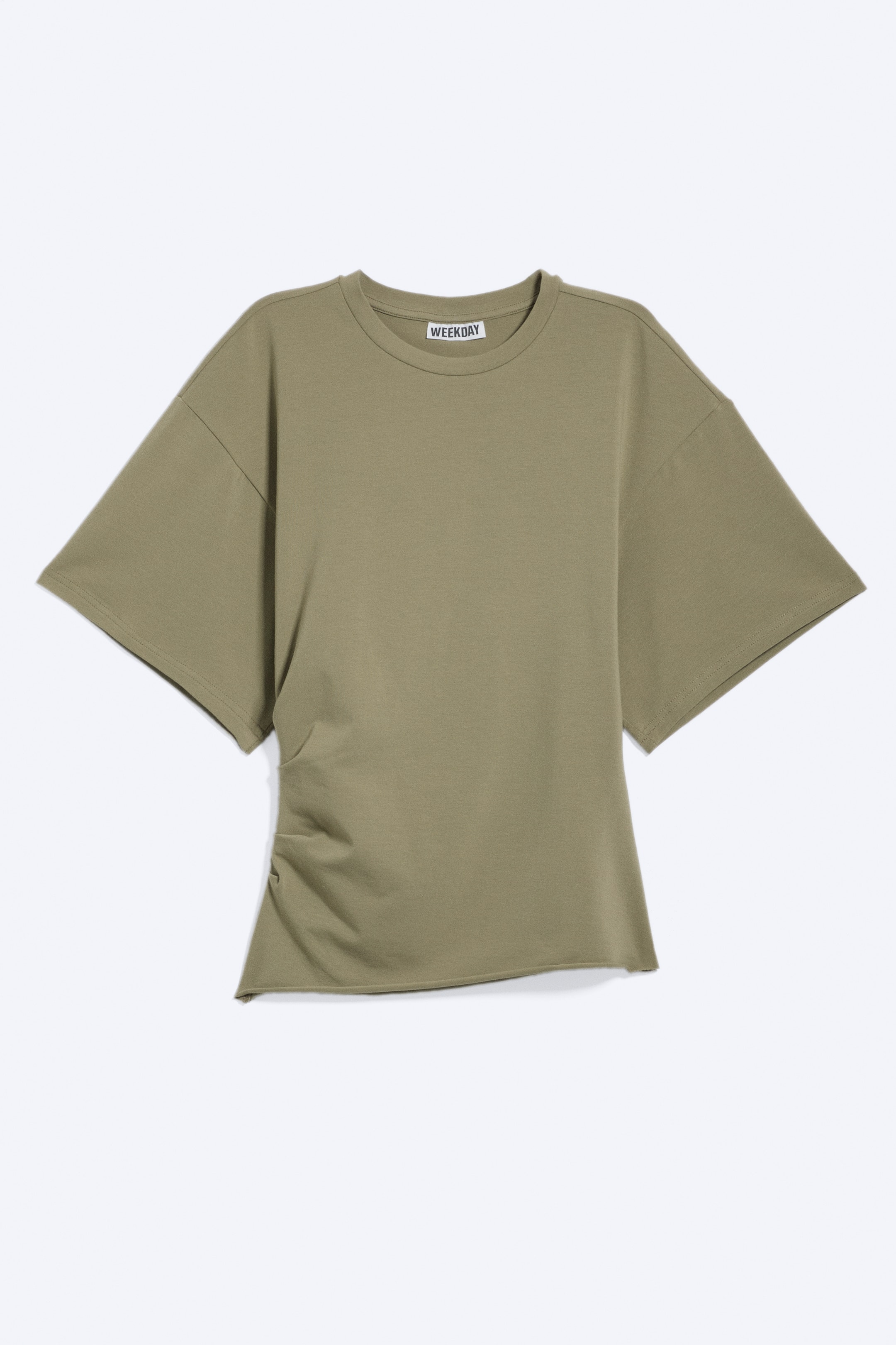 Visualizza l'immagine ingrandita: Una T-shirt mostra la parte anteriore, caratterizzata da un collo rotondo e maniche corte a scatola. Presenta pieghe posizionate che creano un effetto drappeggiato sul lato sinistro e un orlo grezzo lungo il bordo inferiore, con un'etichetta 'WEEKDAY' visibile sullo scollo.