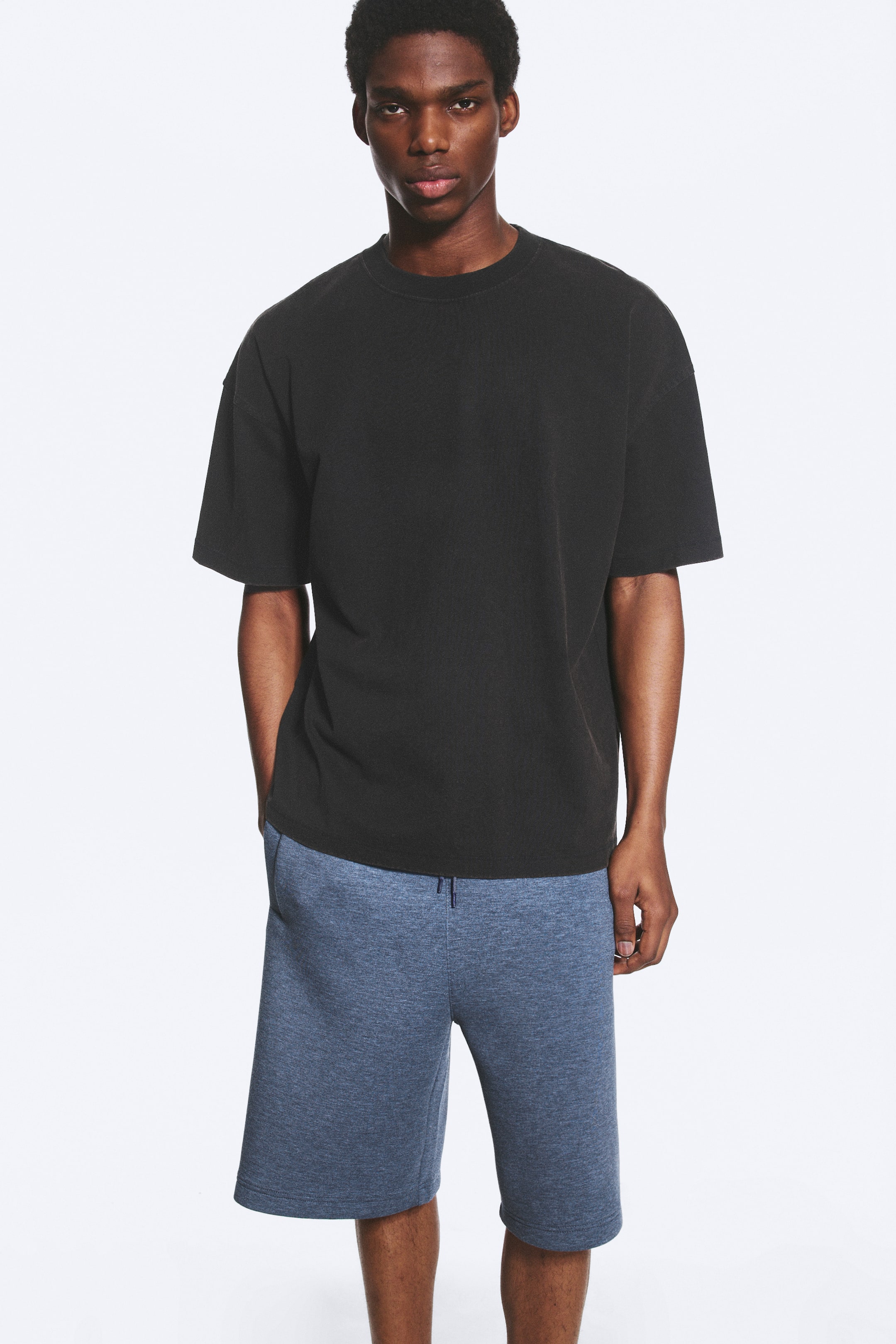 View larger image: Blue heathered knit shorts are showcased from a frontal perspective, featuring a relaxed fit, an elasticated waistband with a visible drawstring, and side pockets.