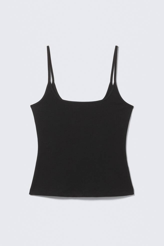 Una camiseta de tirantes negra está de frente, con un escote cuadrado y finos tirantes tipo espagueti. La prenda presenta una silueta ajustada de largo hasta la cadera. - 1