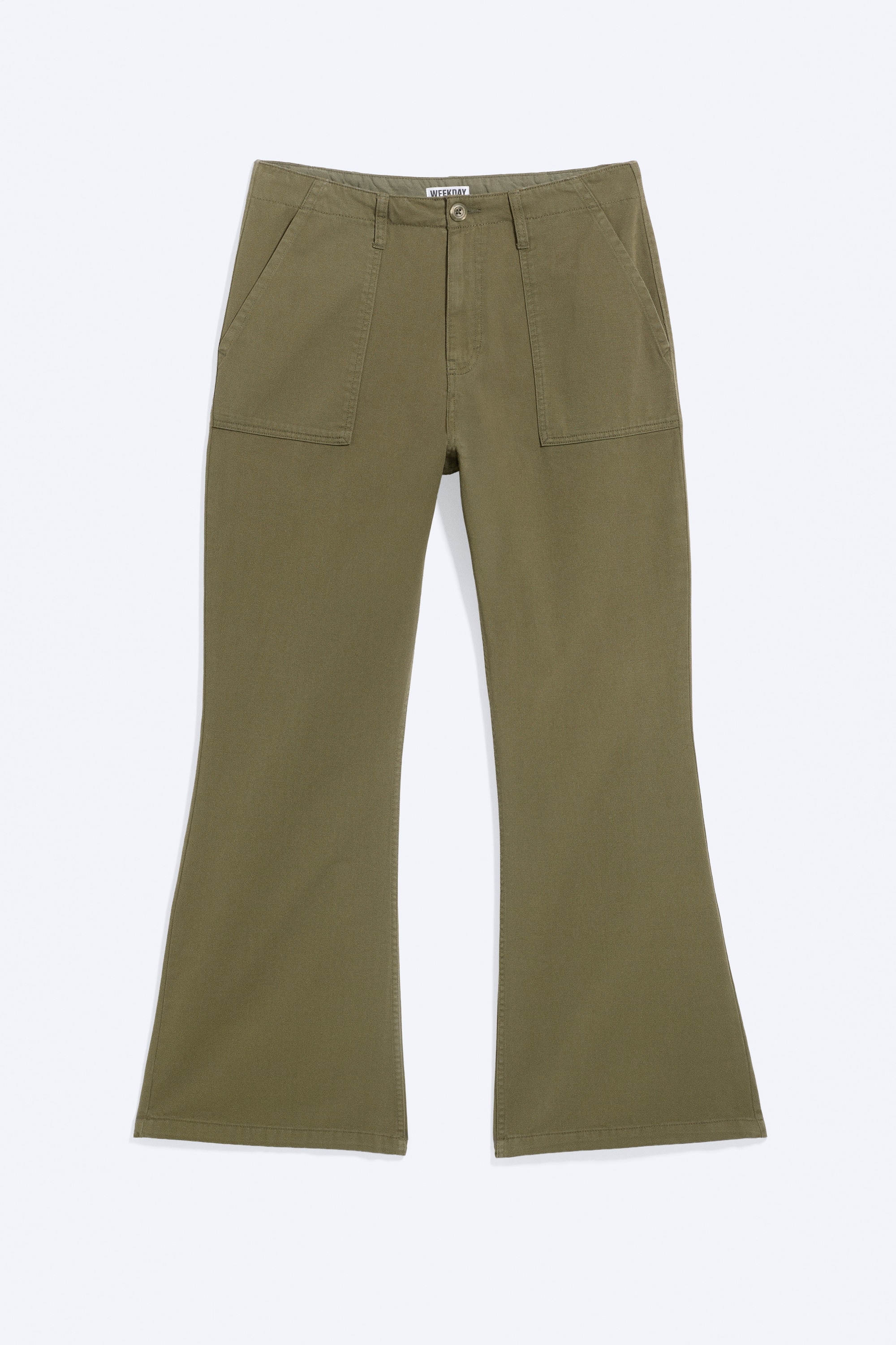 Eine olivgrüne Arbeitshose mit Bootcut-Bein wird vom Model getragen und setzt die hinten mit Patten und Knöpfen versehenen Taschen in Szene. Die Low-Rise-Hose ist mit einem grauen Gürtel mit Ösen und einem dunklen Kapuzenpullover kombiniert.