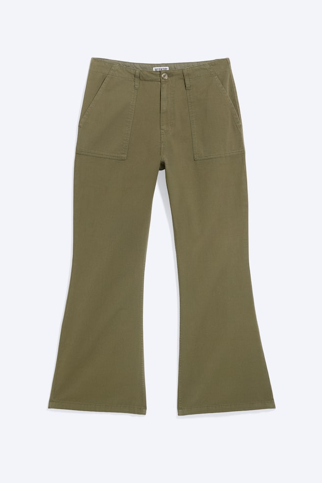 Un pantalon en sergé de coton vert olive est présenté de face, avec une taille basse à fermeture par bouton et des passants de ceinture. Le pantalon met en valeur de grandes poches plaquées à lâavant et une coupe regular qui sâévase à partir du genou pour former une jambe bootcut. - 1