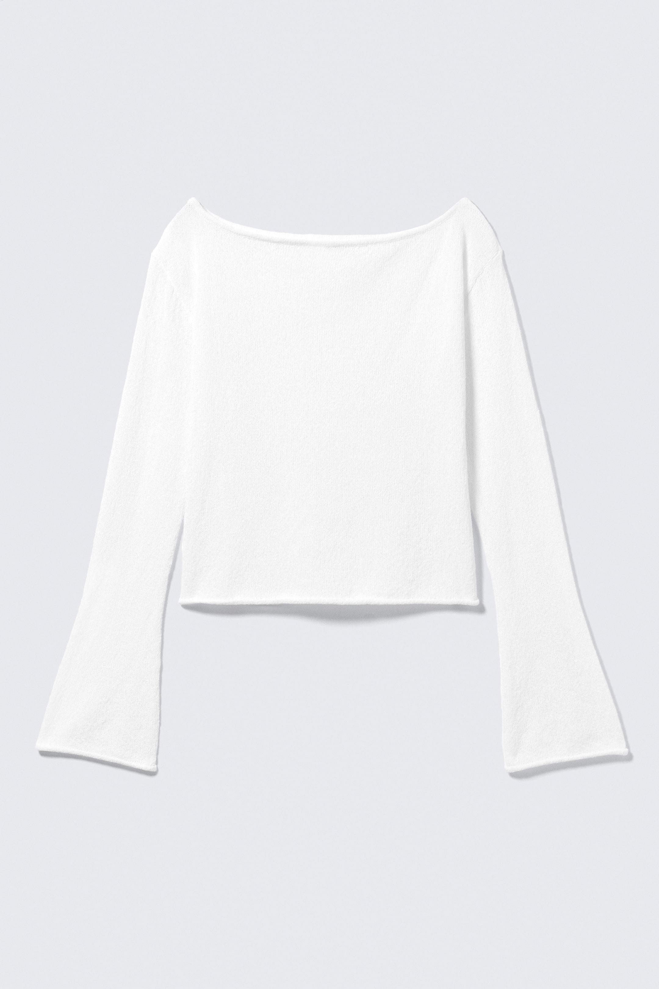 Visualizza immagine più grande: La PARTE ANTERIORE del top bianco corto in maglia presenta uno scollo a barca, maniche lunghe a campana e un orlo non rifinito.