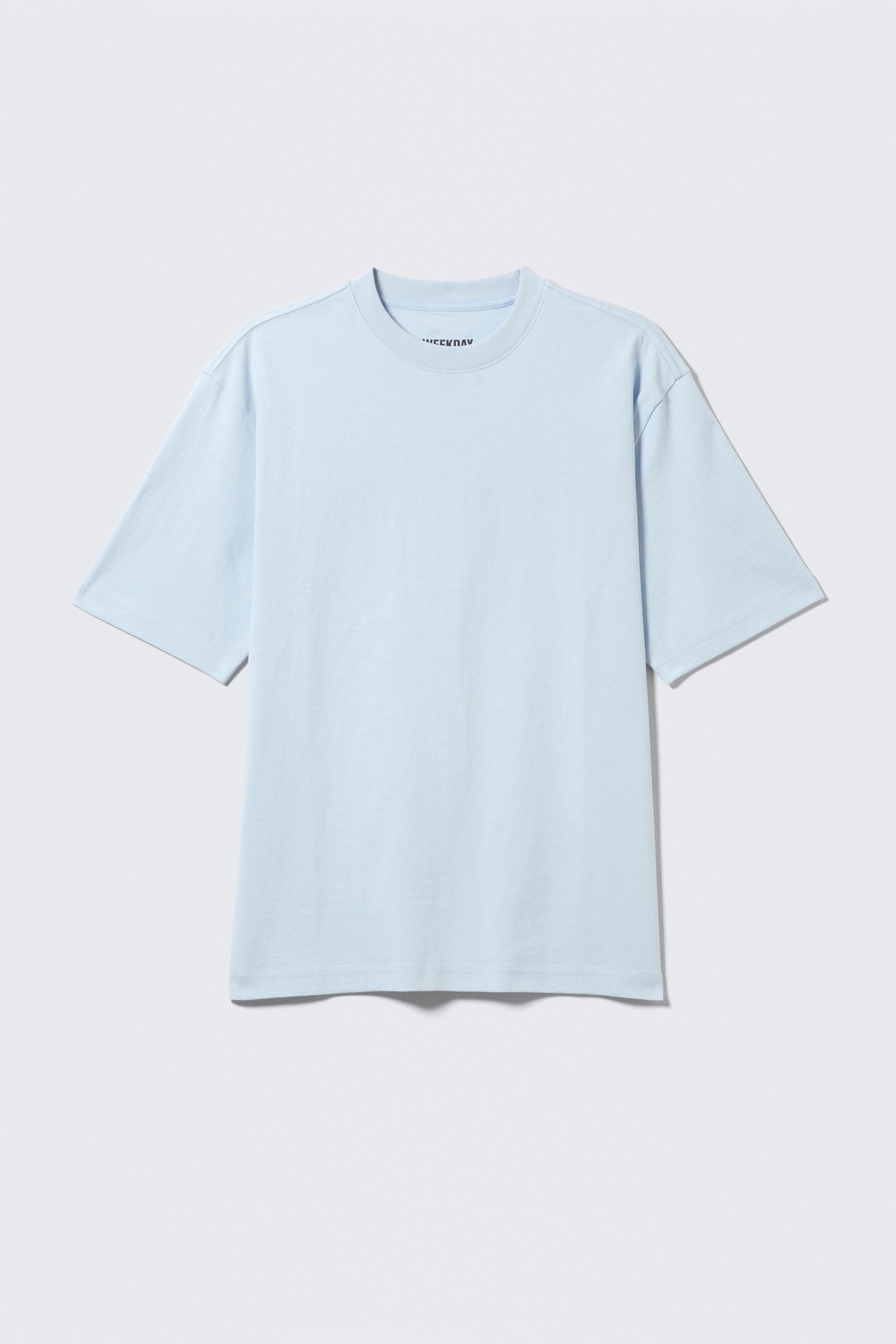 Agrandir l'image: Un T-shirt bleu clair, coupe décontractée, est présenté de face, avec une encolure ras-du-cou classique, des manches courtes et un point de couverture à double aiguille propre aux ourlets des manches et du bas.