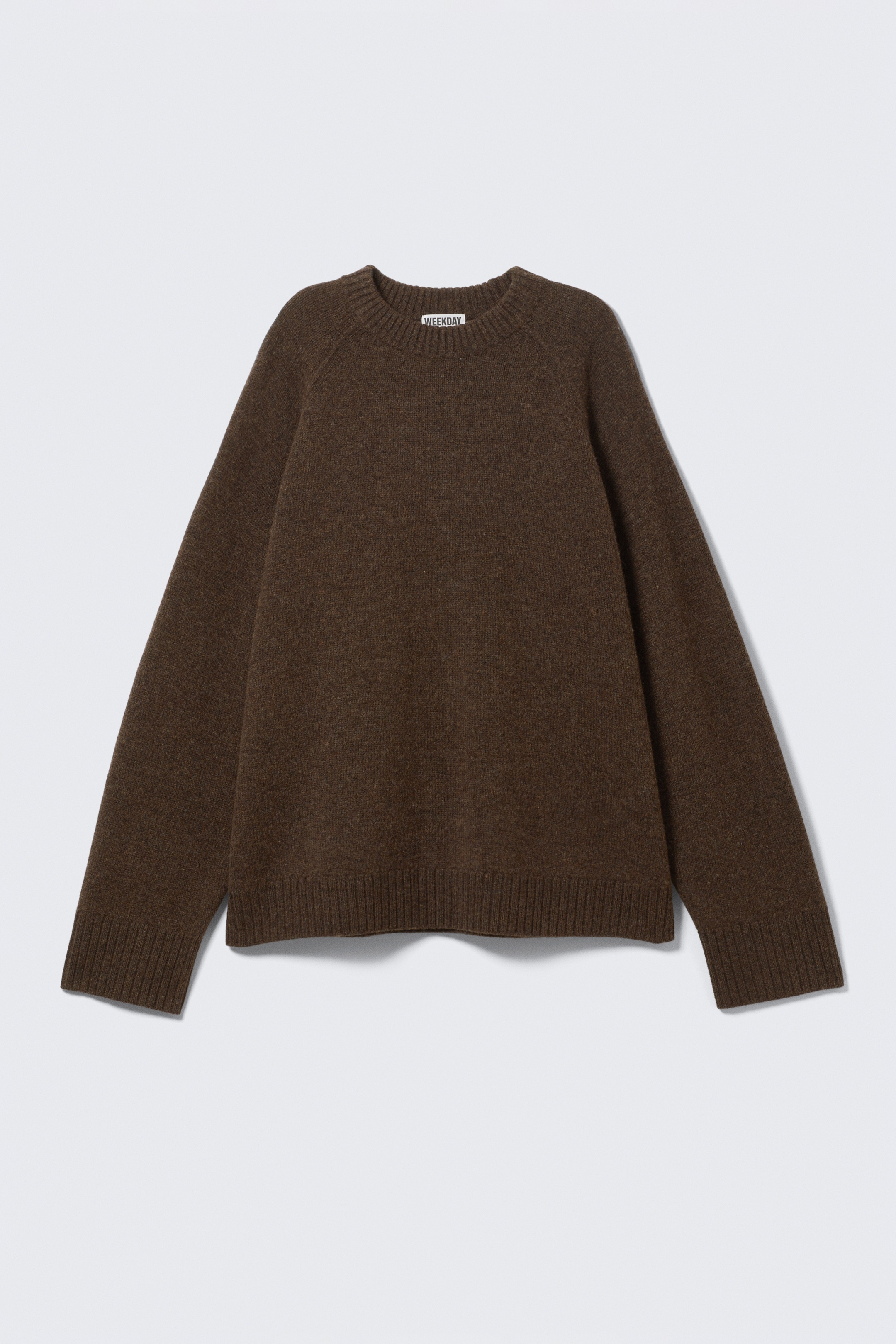 Größeres Bild anzeigen: Ein brauner Strickpullover wird VORNE präsentiert, mit einer lockeren Passform und Raglanärmeln. Er zeigt eine sichtbare Strickstruktur und breite gerippte Abschlüsse an den Bündchen und am Saum.