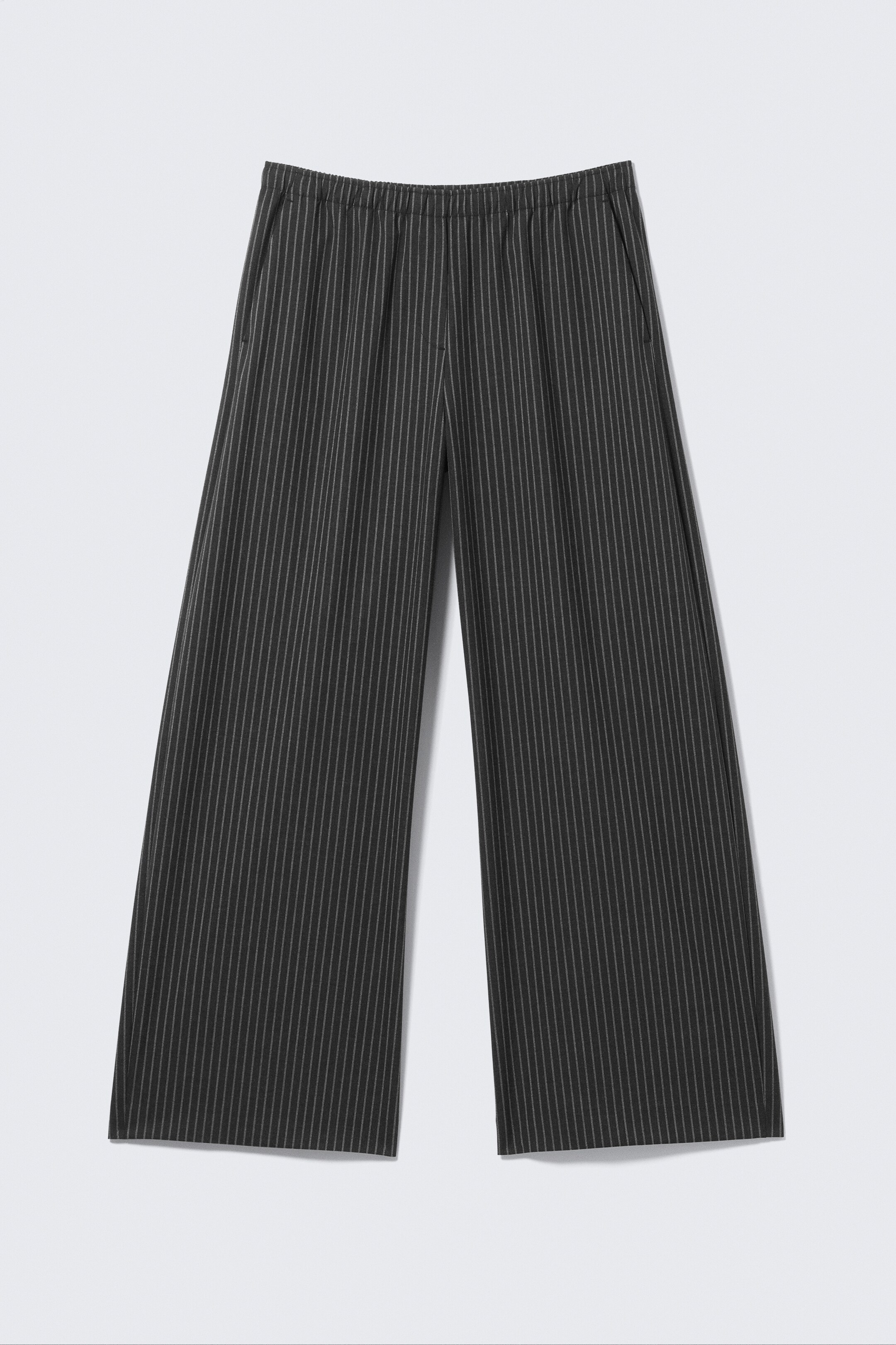 Agrandir l'image: Un pantalon de costume à fines rayures foncées est présenté de face, avec une coupe ample et large, une taille élastiquée, des poches latérales en biais et des ourlets bien finis.
