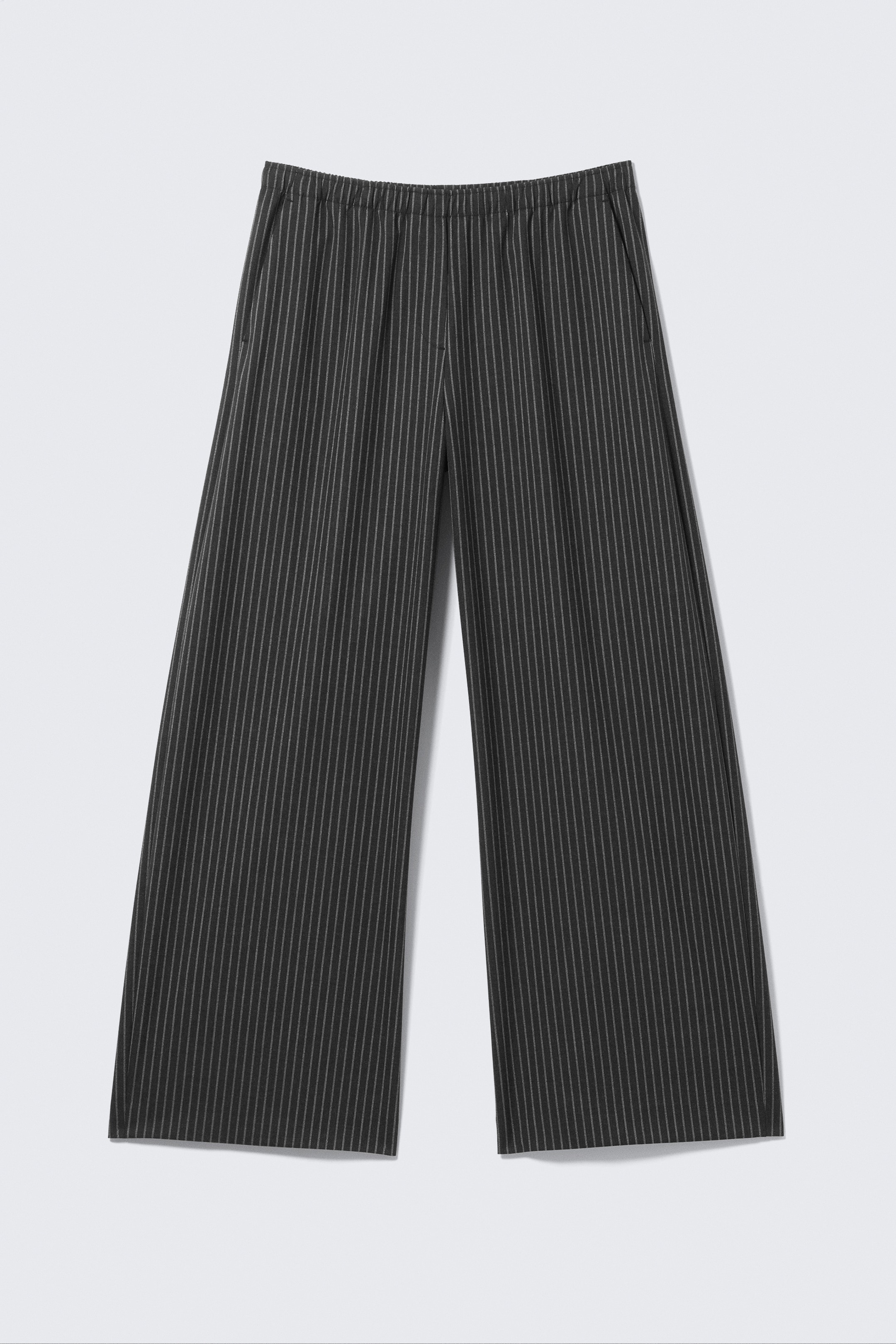 Agrandir l'image: Un pantalon de costume à fines rayures sombres est présenté de face, avec une coupe ample et large, une taille élastiquée, des poches latérales en biais et des ourlets bien finis.