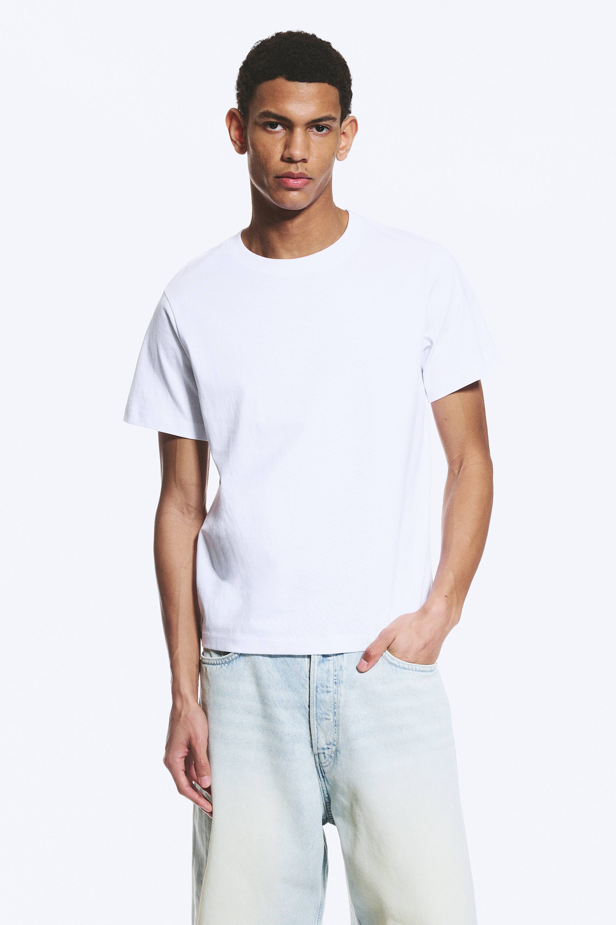 Grösseres Bild ansehen: Ein weisses T-Shirt mit geripptem Rundhalsausschnitt und kurzen Ärmeln, das locker am Oberkörper sitzt.