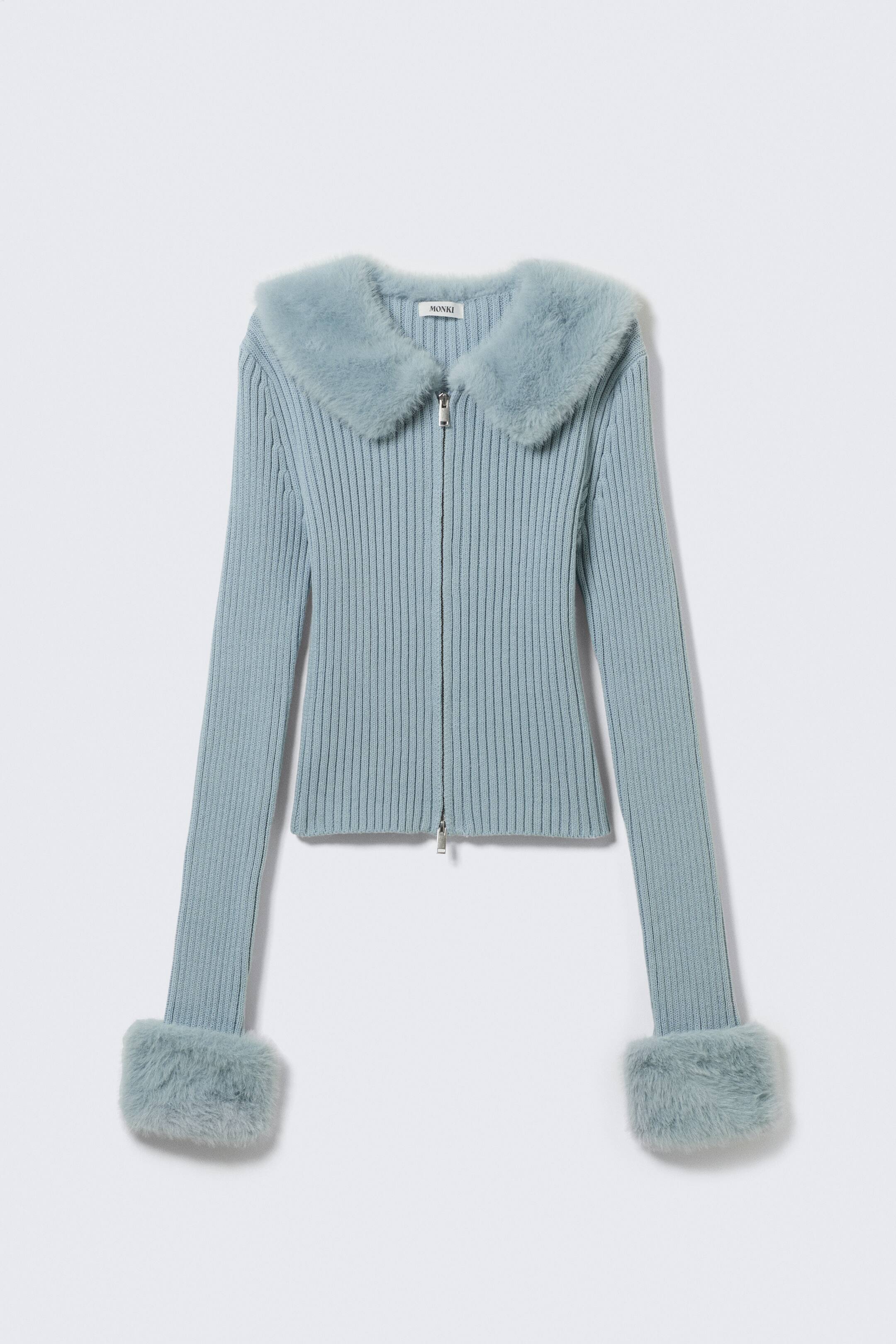 Agrandir l'image: Un cardigan en maille côtelée bleu clair est présenté de FACE, avec un large col en fausse fourrure et des poignets assortis en fausse fourrure. Une fermeture éclair de couleur argentée descend le long du centre avant.