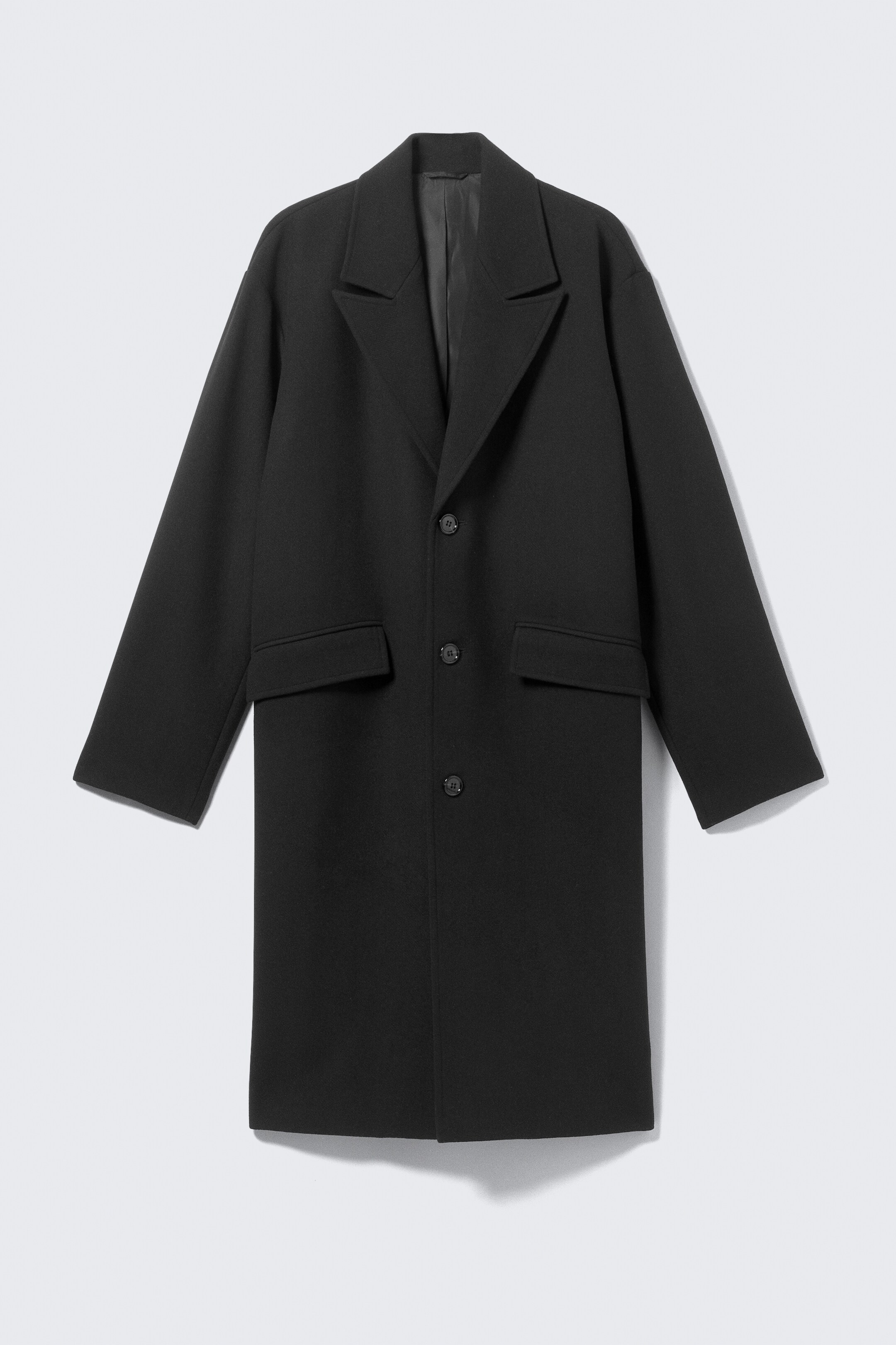 Agrandir l'image: Un manteau noir à simple boutonnage est présenté de face, avec des revers crantés, une fermeture à trois boutons et deux poches à rabat aux hanches. Il présente des manches longues avec des poignets simples et une coupe droite.