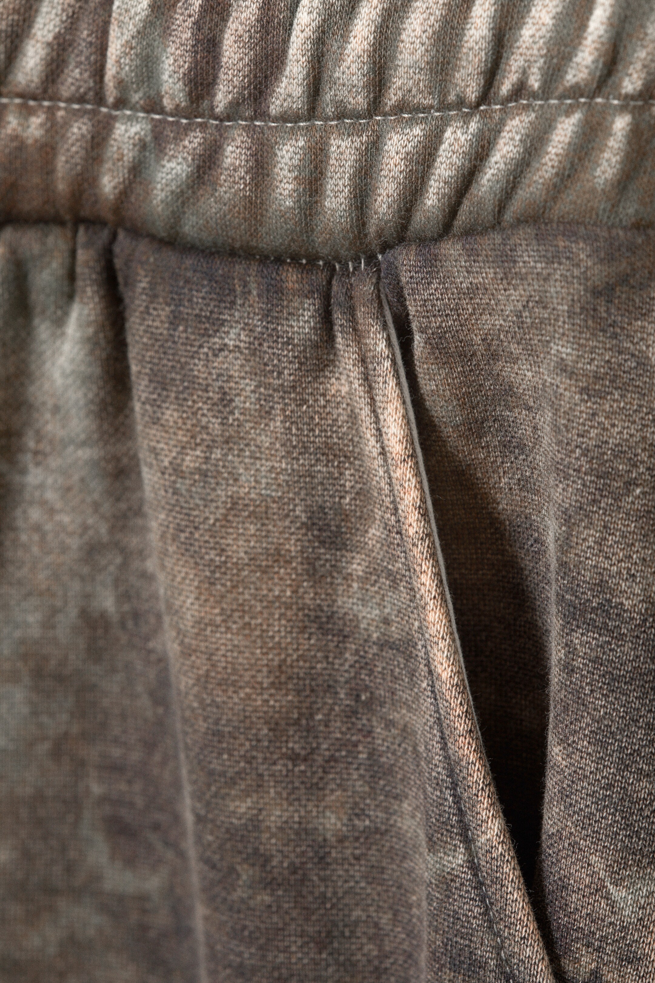 View larger image: A pair of brown and grey mottled pants is presenting its FRONT, featuring a gathered waistband with horizontal stitching, and a diagonal side slash pocket.