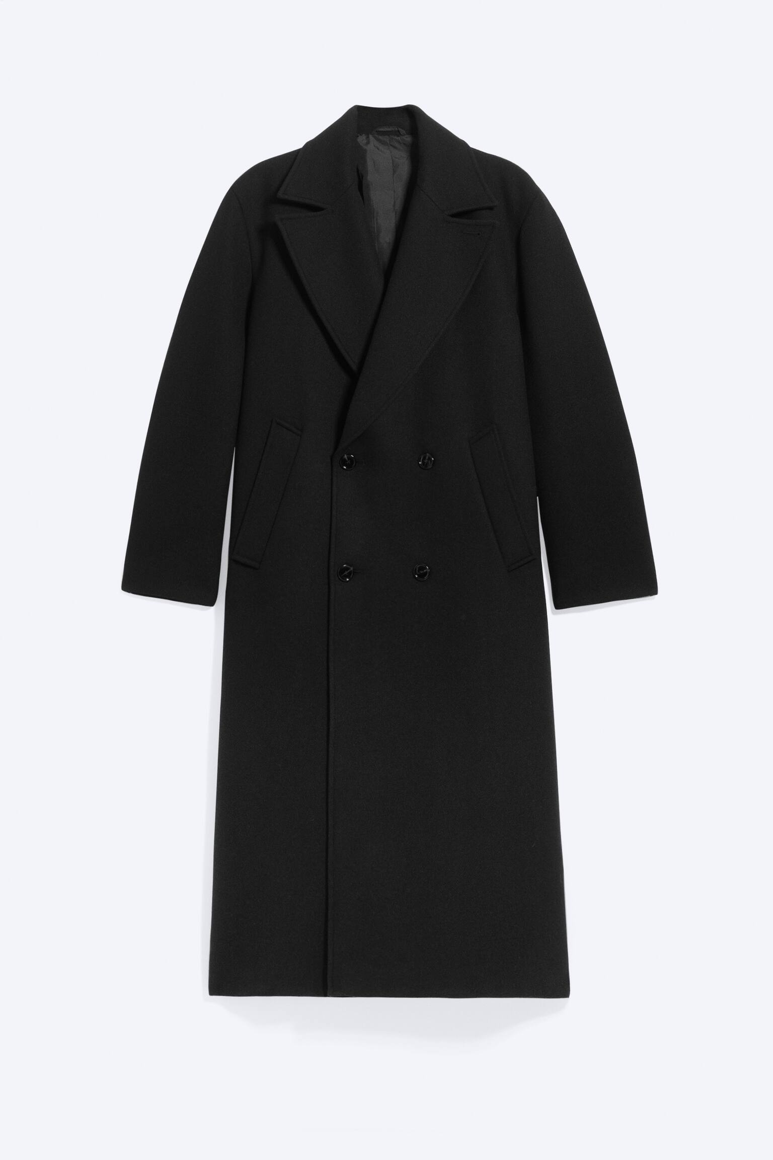 DlhÃ½ Äierny kabÃ¡t z vlnenej zmesi je otoÄenÃ½ spredu a zobrazuje oversized siluetu. MÃ¡ dvojradovÃ© zapÃ­nanie na gombÃ­ky, Å¡irokÃ© klopy s vÃ½strihom do zÃ¡rezu a Å¡ikmÃ© vaÄkovÃ© vreckÃ¡. - 1