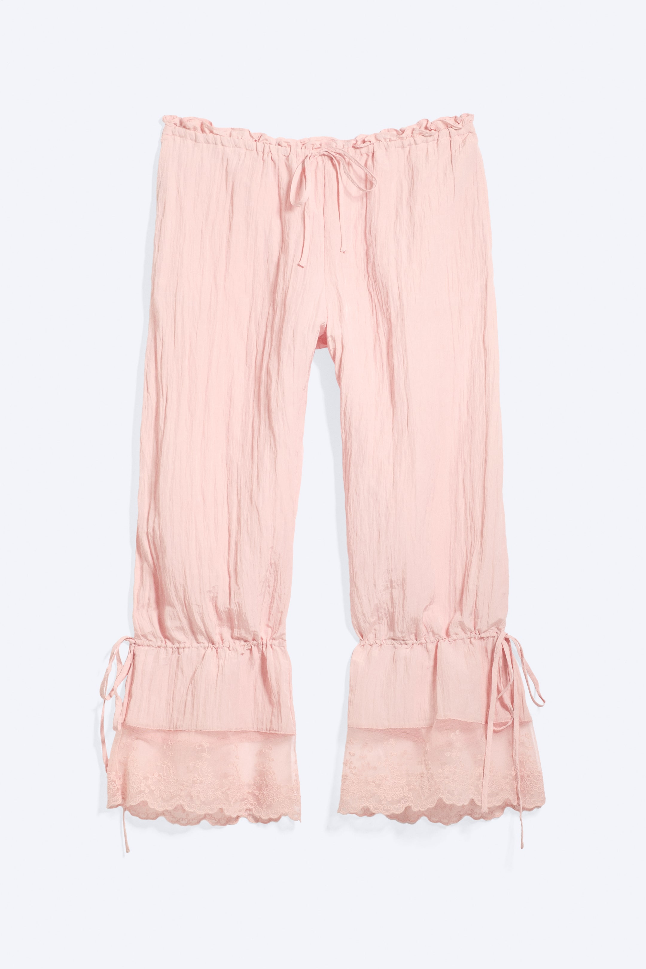 Visualizza immagine più grande: Un paio di pantaloni alla turca rosa, stropicciati e larghi, è mostrato frontalmente, caratterizzato da una vita elasticizzata con coulisse arricciata. Le gambe a tre quarti terminano con orli larghi e raccolti, dettagliati con uno strato interno rifinito in pizzo e coulisse regolabili.