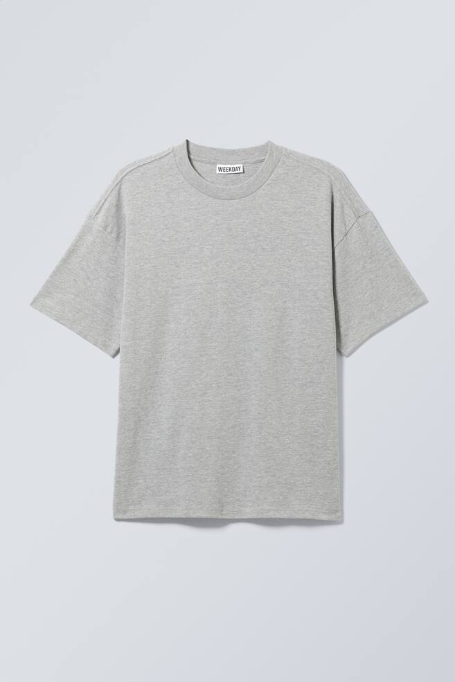 En ljusgrå melerad t-shirt visas framifrån, med en oversized passform, sänkta axlar och vida korta ärmar. Den är tillverkad med en ribbad rund hals och en rak fåll, vilket ger en ren och enkel design. - 1