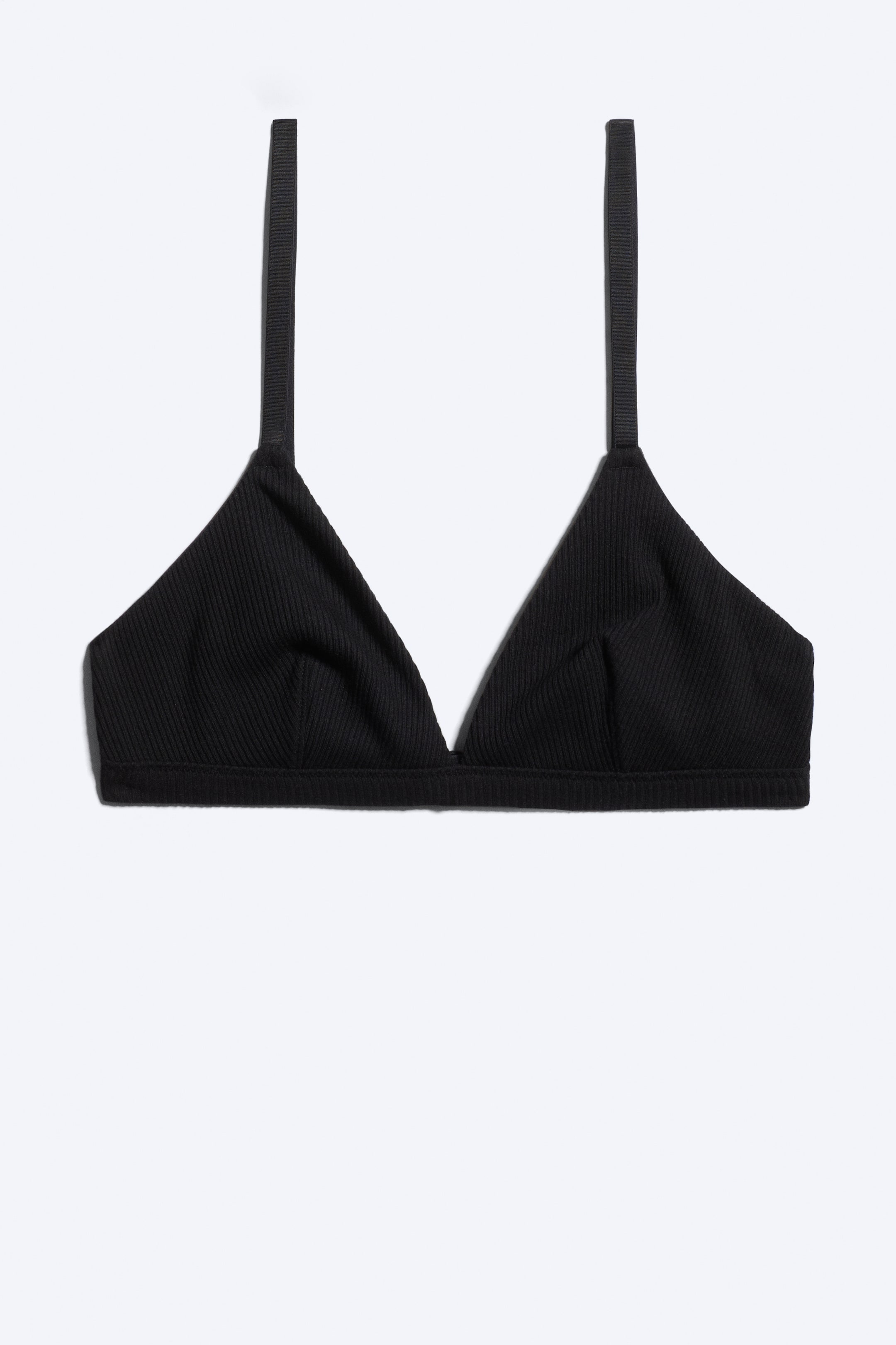 Grotere afbeelding bekijken: Een zwarte geribde triangle bralette is van voren weergegeven, met zachte driehoekige cups van ribgebreide stof met een bijpassende elastische onderband en dunne schouderbandjes.