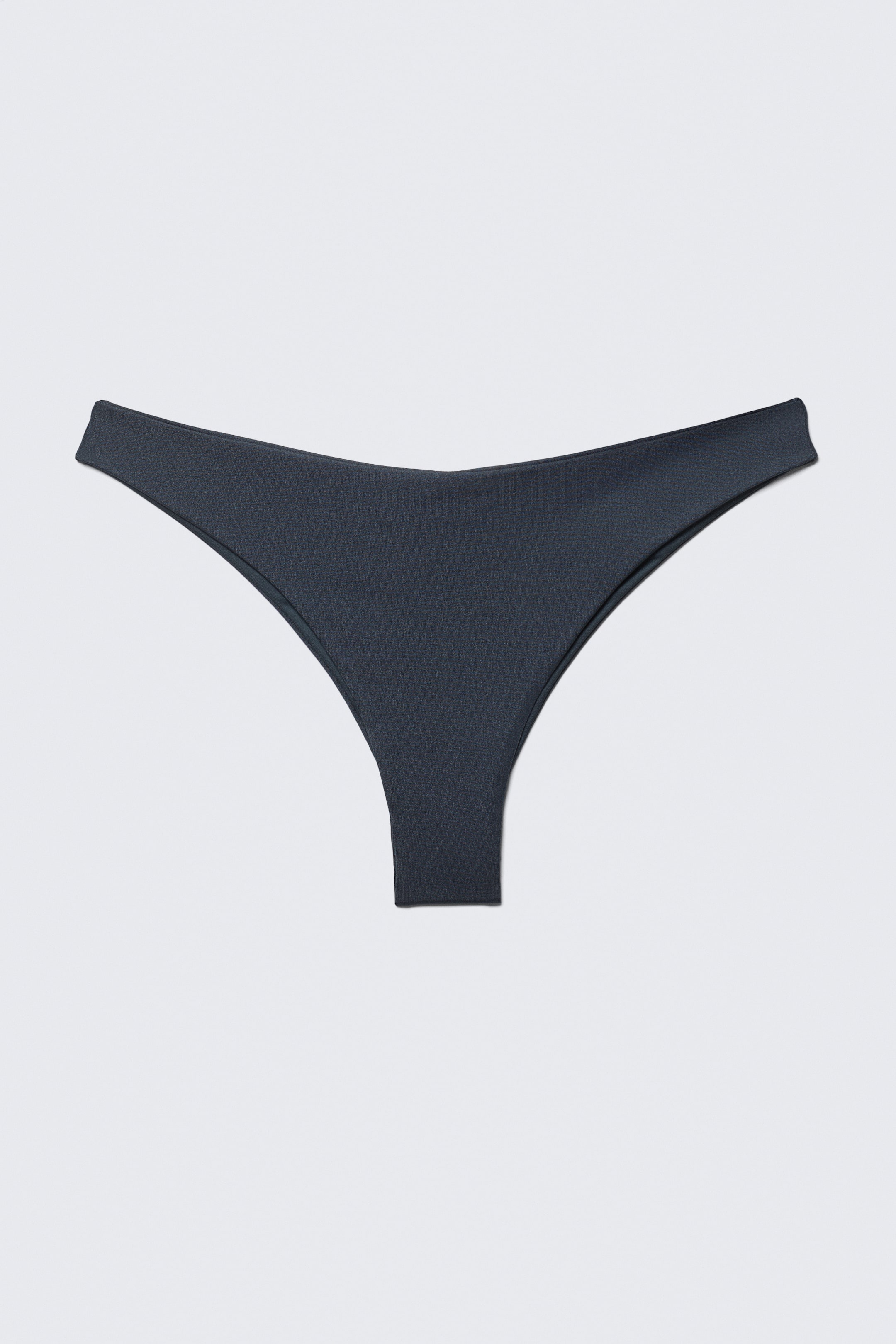 Se større billede: En mørkegrå bikiniunderdel vises i frontperspektiv, med et højt skåret design og minimal dækning. Den fremhæver en blød, flad linning og næsten sømløse kanter.