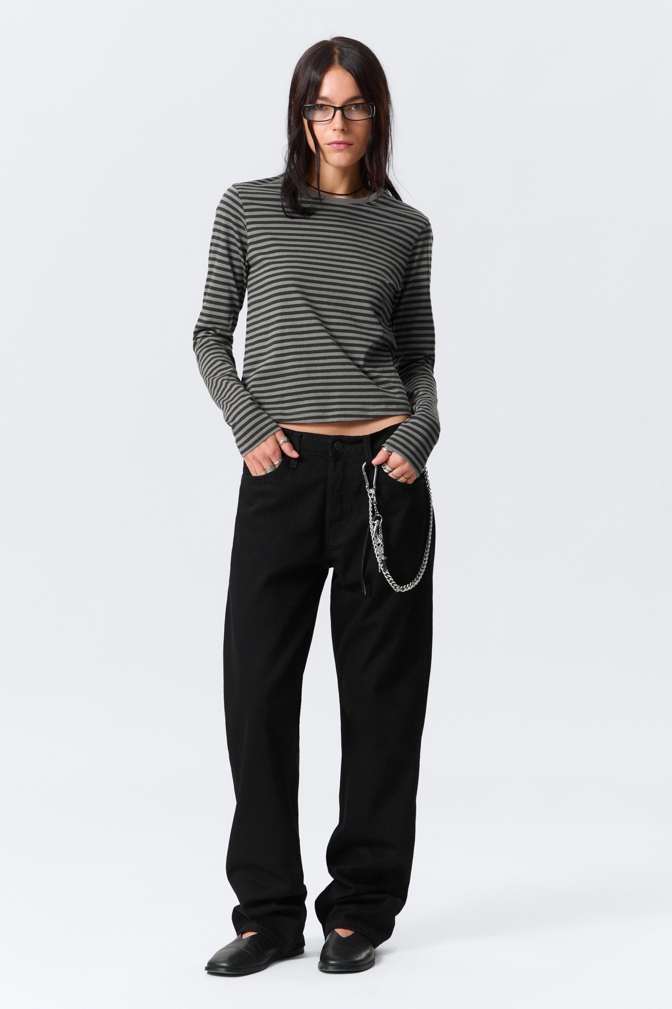 View larger image: A long-sleeved top is featuring horizontal stripes in dark gray and muted green. It is designed with a crew neck and a cropped hem, fitting snugly on the wearer.