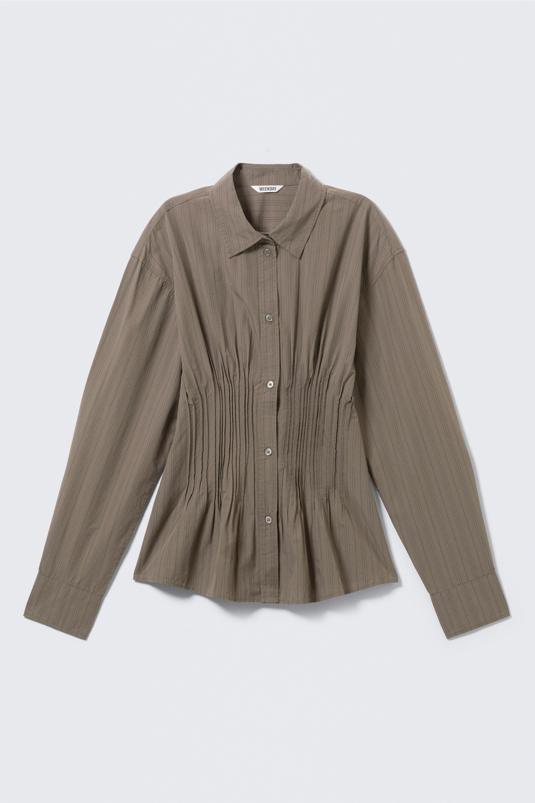 View larger image: The long-sleeved shirt, showcased from the front, features a pointed collar, a button-front fastening, and wide cuffs. It displays a tailored waist with prominent gathered detailing, a neat curved hem, and fine vertical stripes running across the fabric.