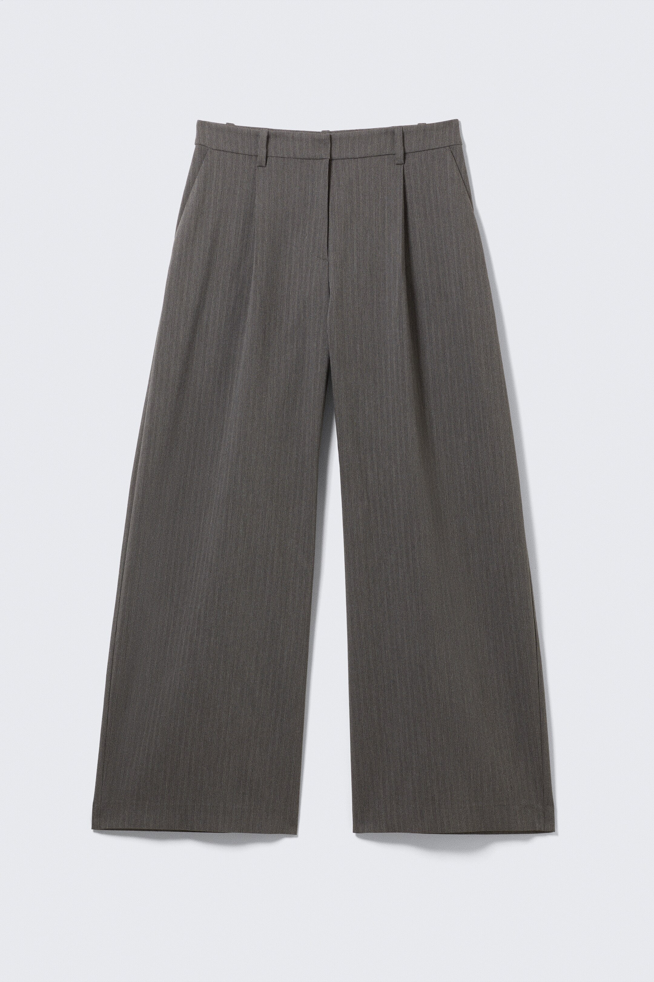 Ingrandisci l'immagine: Un paio di pantaloni da abito grigio scuro è mostrato dal davanti, caratterizzato da un sottile motivo a righe verticali, una chiusura con zip e gancio, tasche laterali oblique e gambe ampie e spaziose con pieghe frontali.
