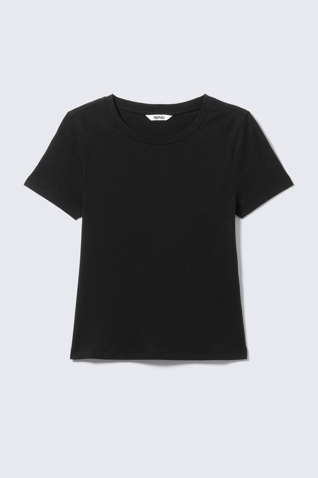 Ein schwarzes T-Shirt zeigt seine Vorderansicht, mit Rundhalsausschnitt, kurzen Ärmeln und einem geraden Saum. Ein weißes 'MONKI'-Label ist am inneren Rückenausschnitt sichtbar. - 1