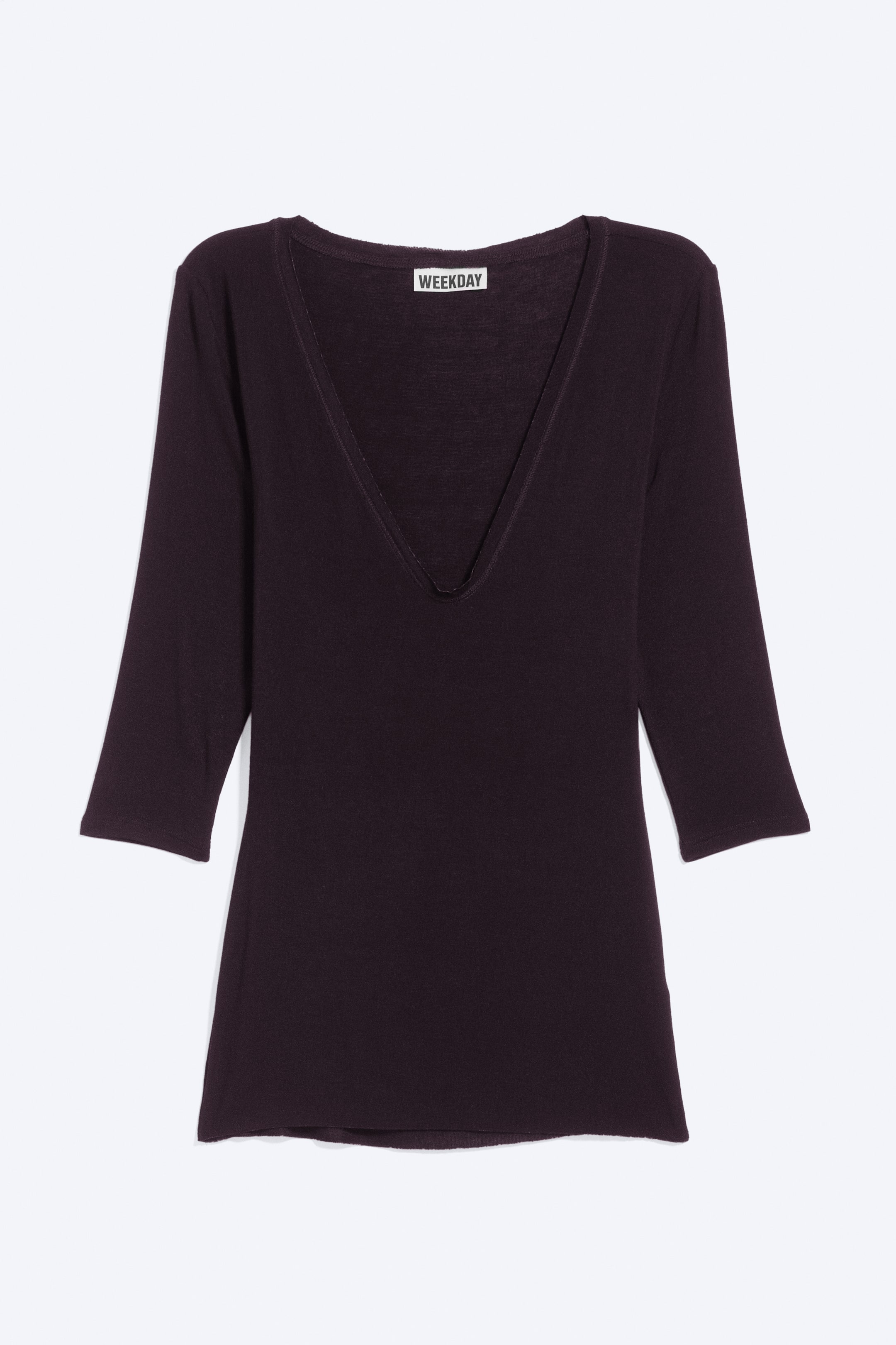 Vezi imaginea mai mare: Un top de culoare prune închisă, cu decolteu adânc în V și mâneci trei sferturi, este prezentat din față. Piesa slim-fit prezintă o textură moale, fin tricotată și un tiv drept.