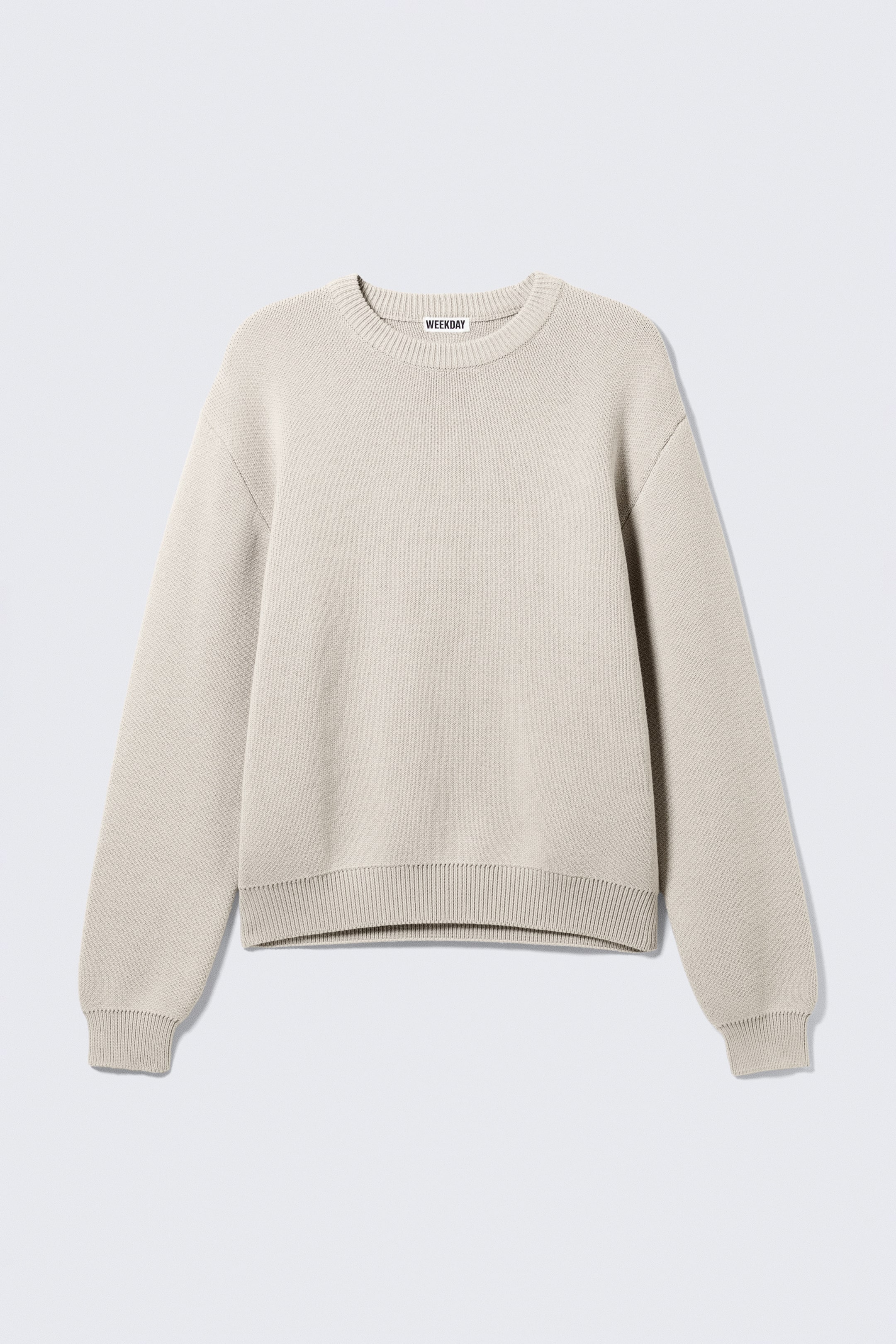 Visa större bild: En ljusbeige, regular-fit tröja visas framifrån, med en tät stickad textur, en rund ribbstickad halsringning med en 'WEEKDAY'-märkesetikett, långa ärmar med ribbade muddar och en ribbad bottenfåll.