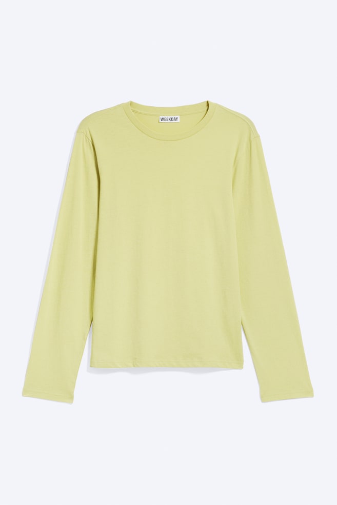 A long-sleeved T-shirt in light lime green is shown from the front, featuring a classic crew neck, long sleeves, and a straight hem. - 1