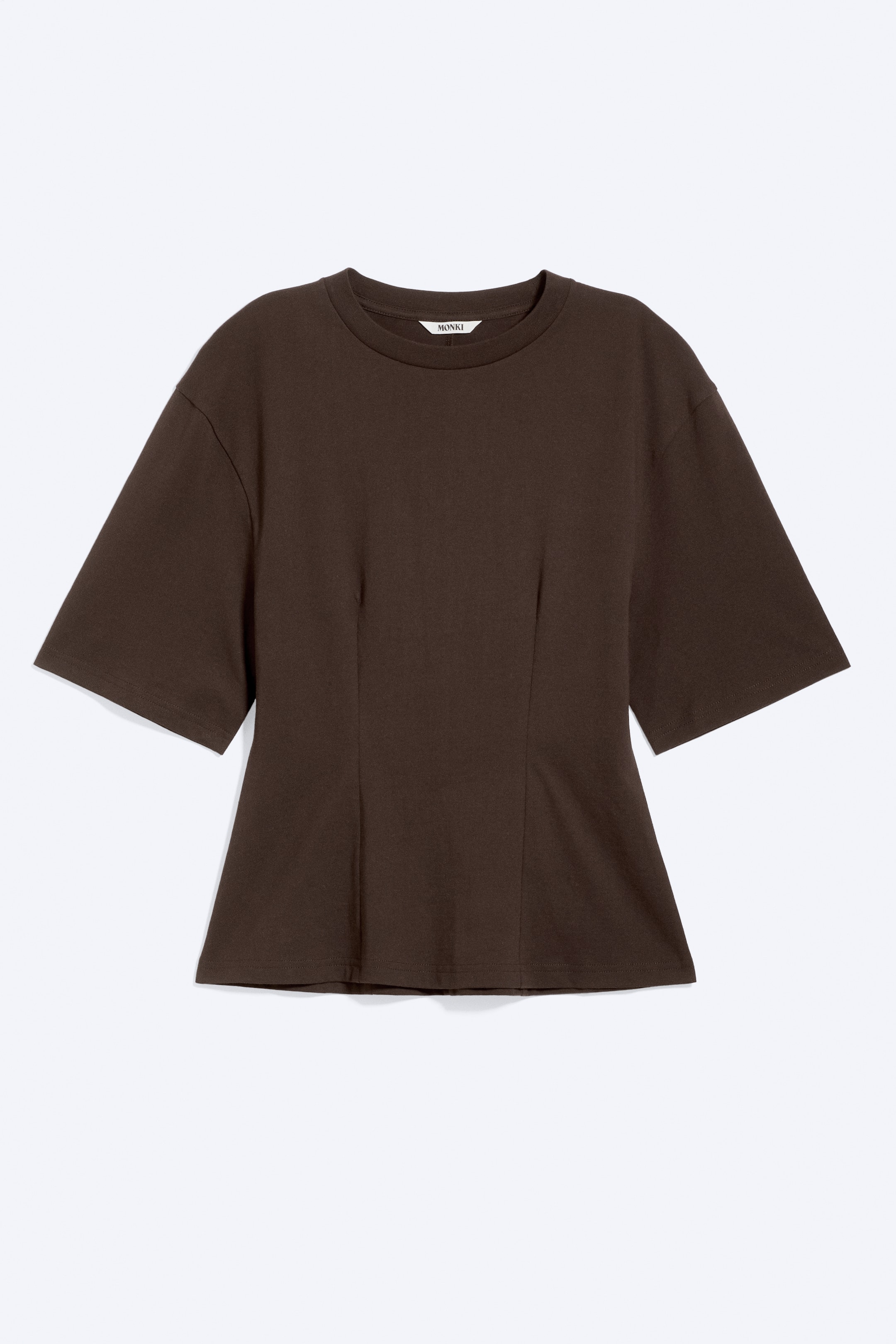 Ver imagen más grande: Una camiseta marrón oscuro presenta un cuello redondo, mangas cortas con un hombro ligeramente caído y pinzas verticales en la parte delantera. Estas pinzas crean una cintura ajustada que se ensancha suavemente hacia el dobladillo.